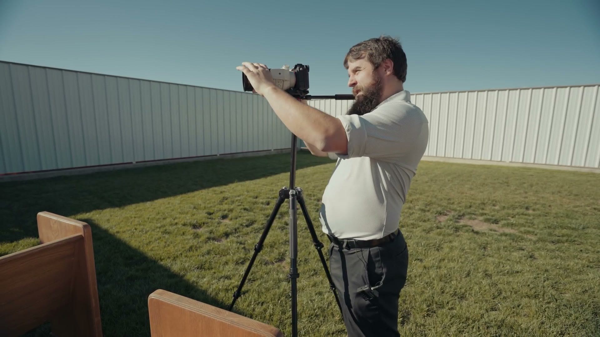 Long lens on a tripod in a field