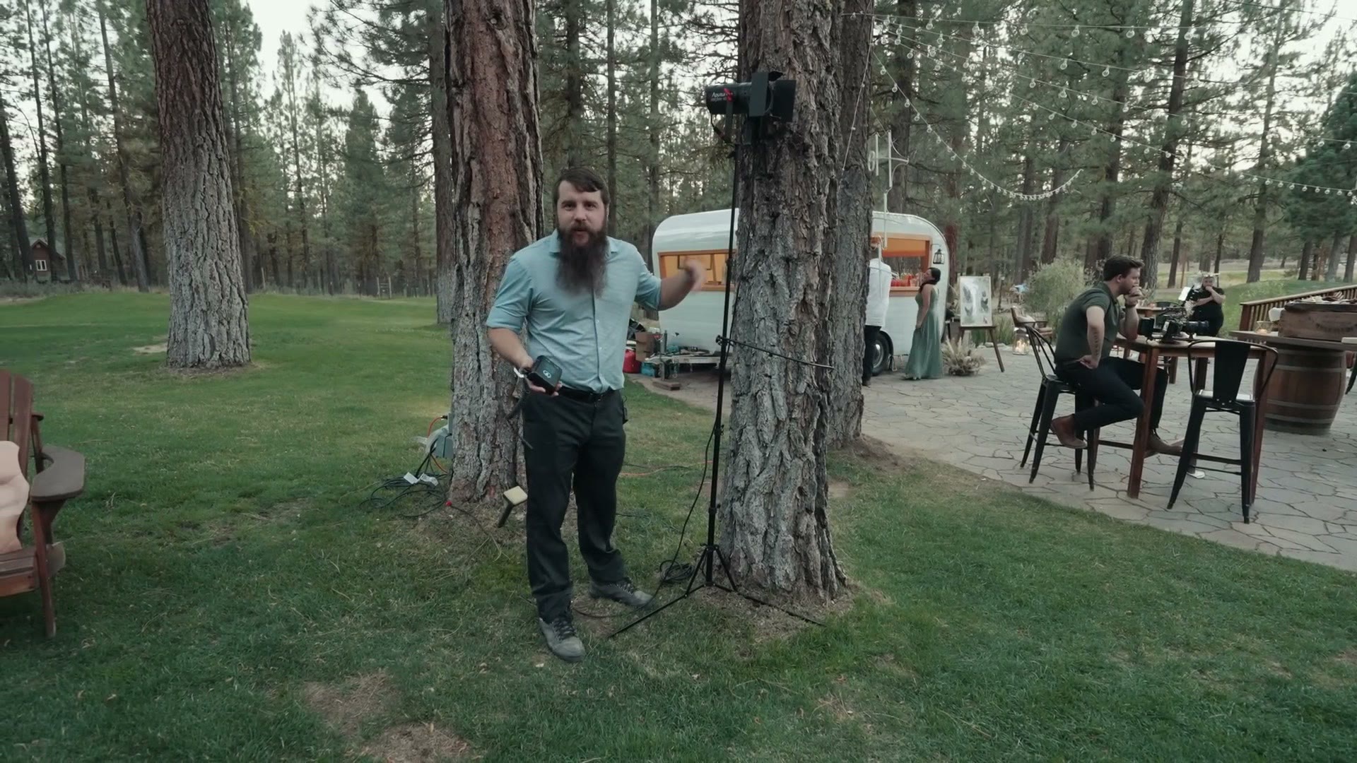 A light stand lashed to a pine tree with an extension cord