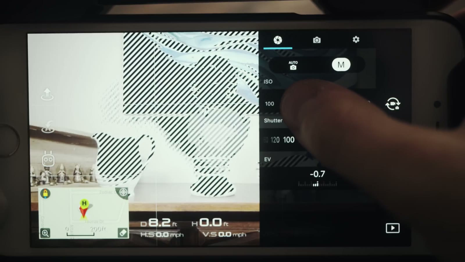 The DJI Go screen with zebra stripes covering the blown out highlights of the frame, beside the manual exposure controls