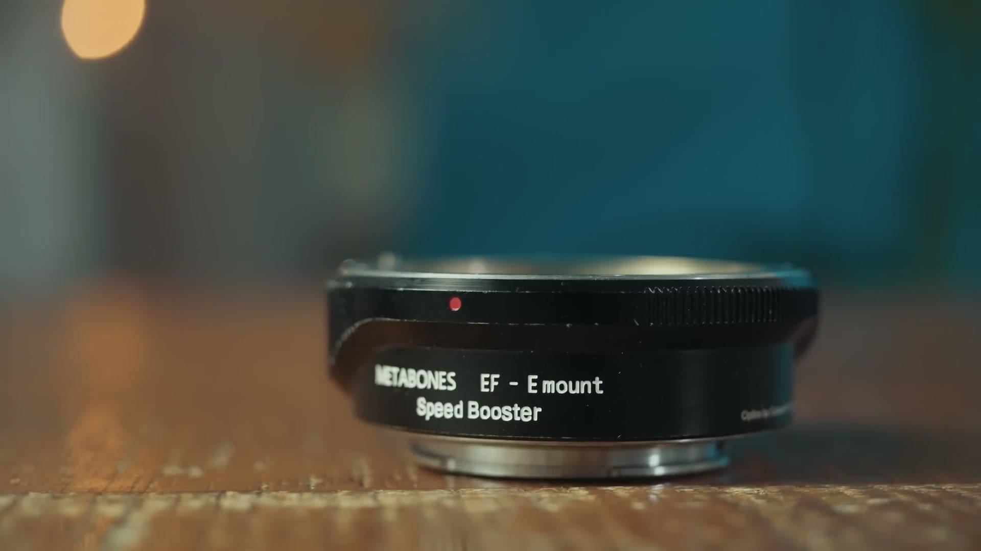 A Metabones EF to E-mount Speed Booster adapter on a table