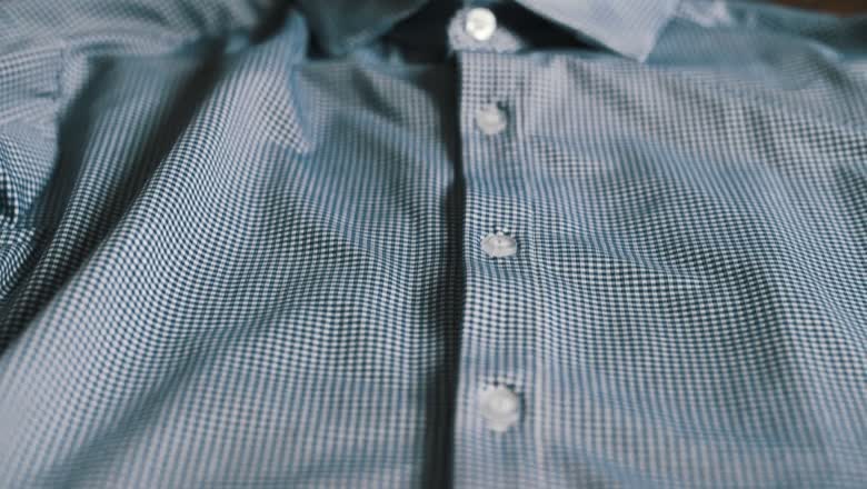 Close-up of a blue and white checked Mizzen and Main dress shirt showing the fine gingham weave and buttons