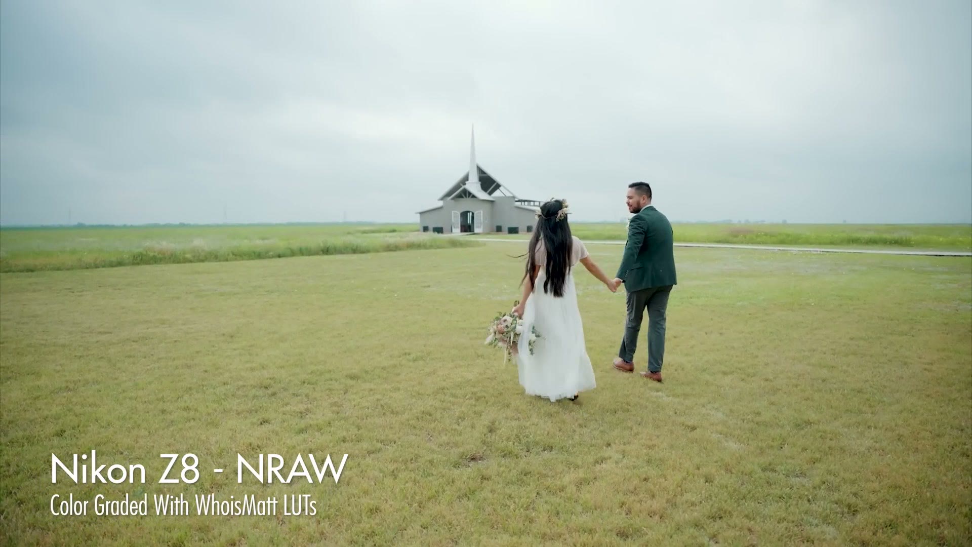 A bride and groom walking through a field toward a chapel, labeled Nikon Z8 - NRAW, color graded with WhoisMatt LUTs