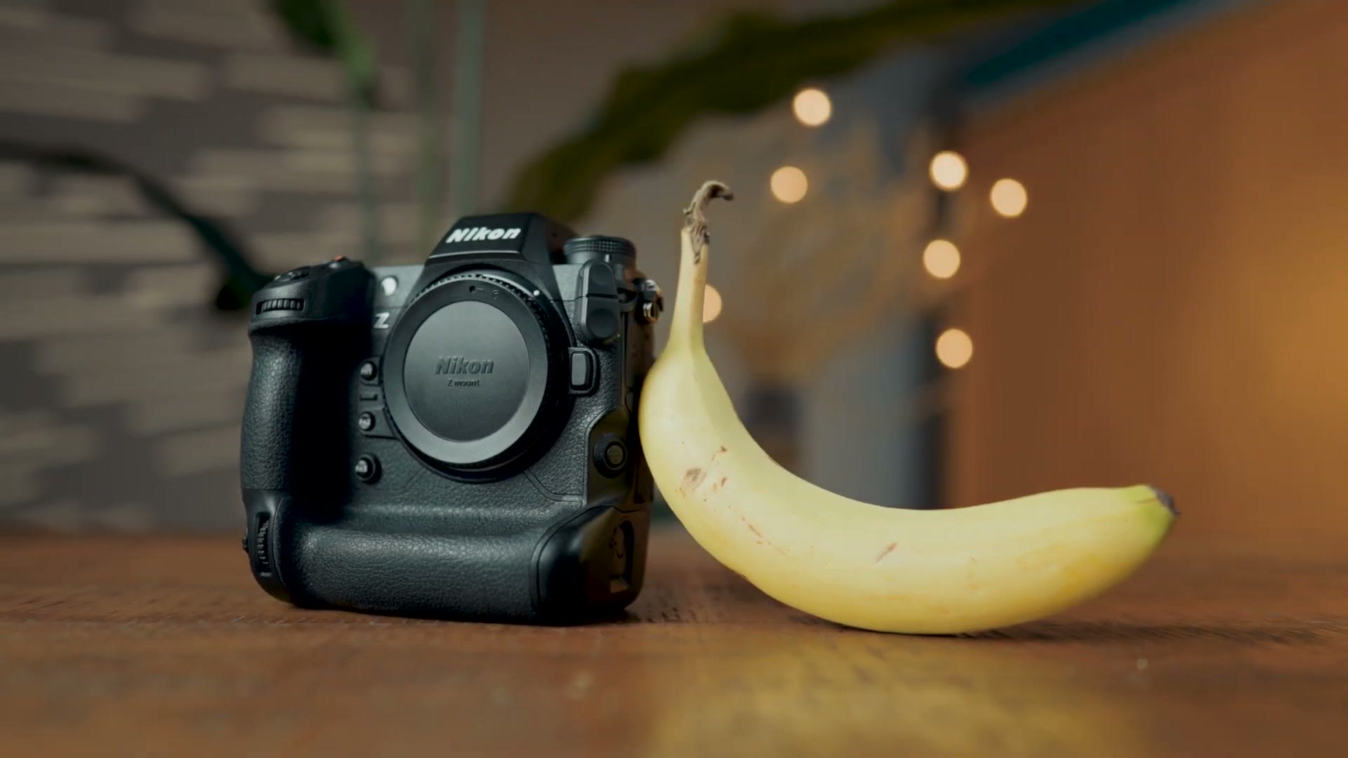 Nikon Z9 sitting on a table next to a banana for scale