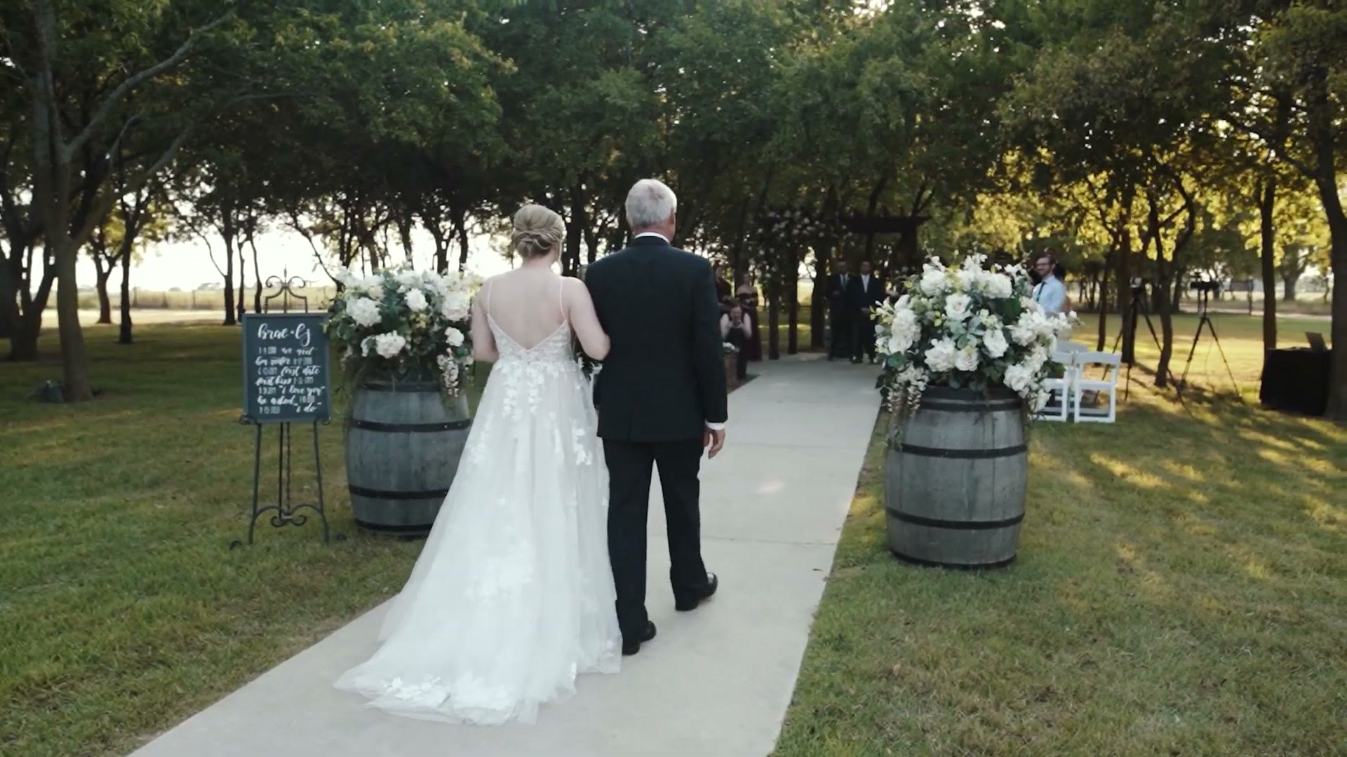 An outdoor wedding ceremony with a bride walking down the aisle