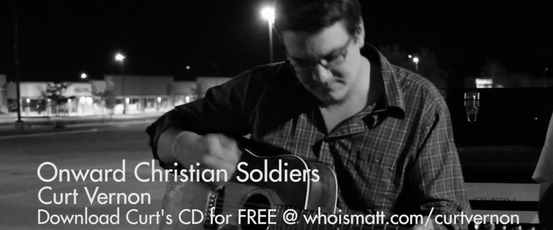 Black and white shot of Curt Vernon playing guitar in a parking lot at night, titled Onward Christian Soldiers with a download link