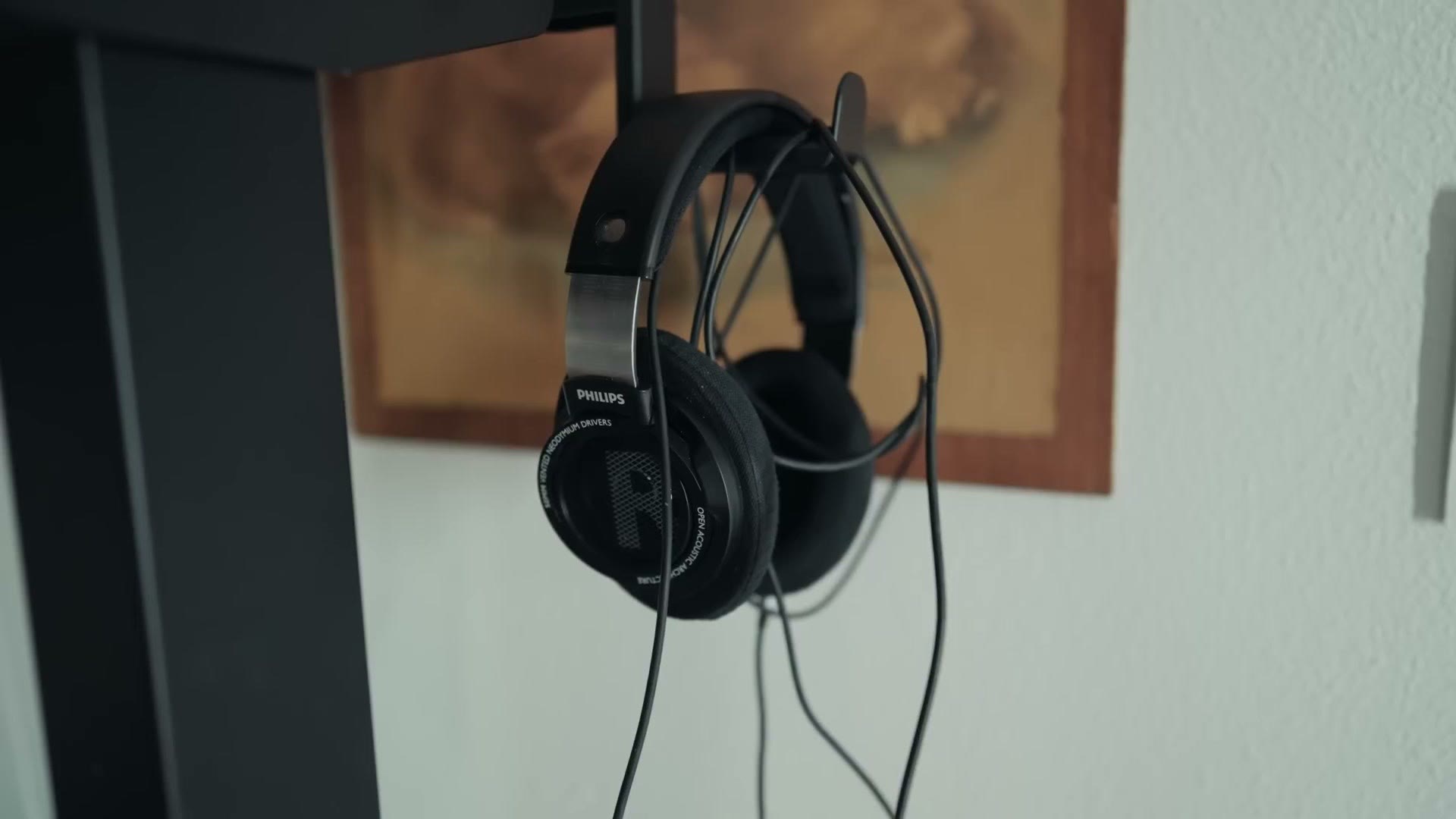 Philips headphones hanging on a desk mount