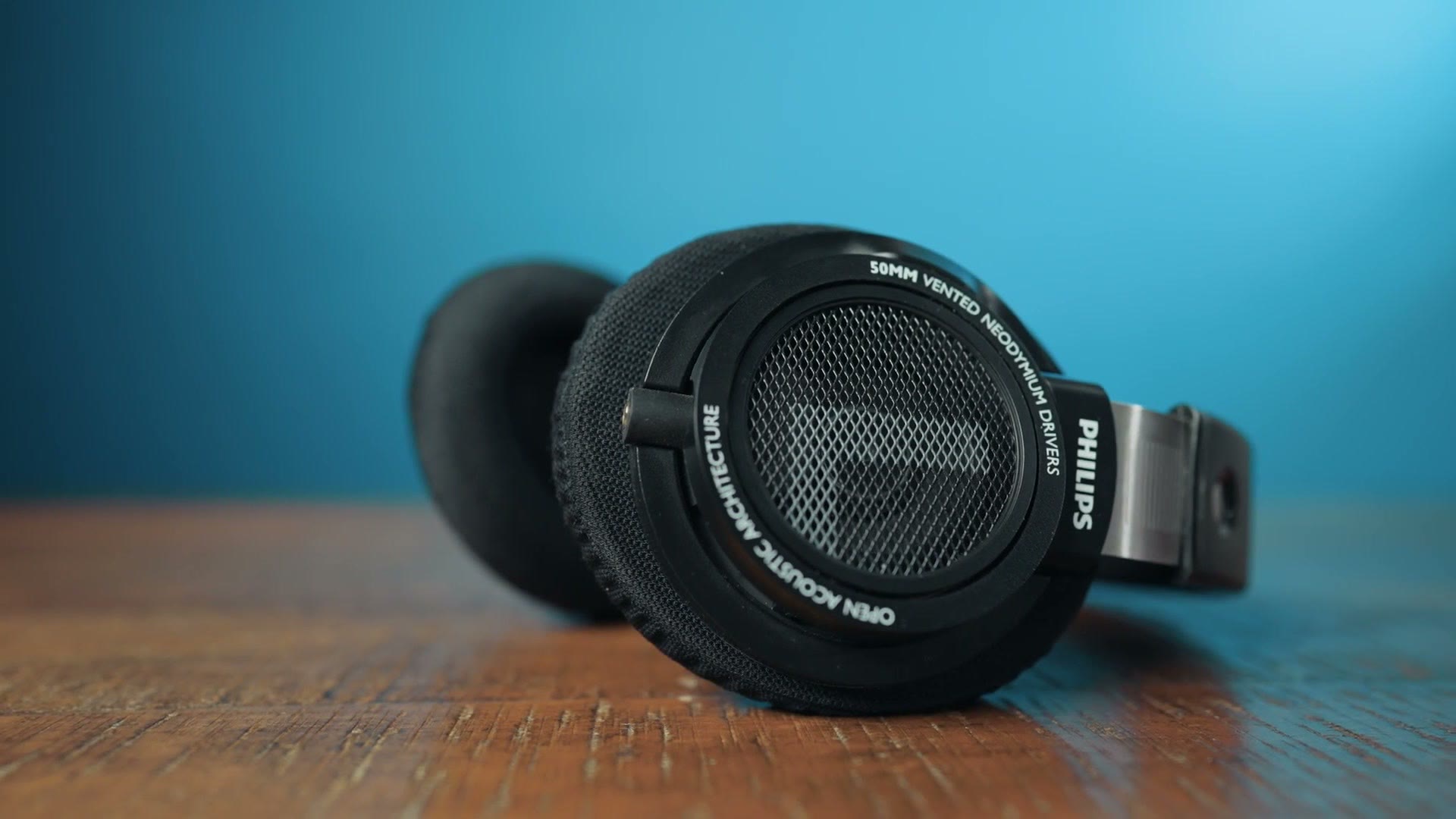 Philips SHP9500 open back headphones sitting on a wooden table