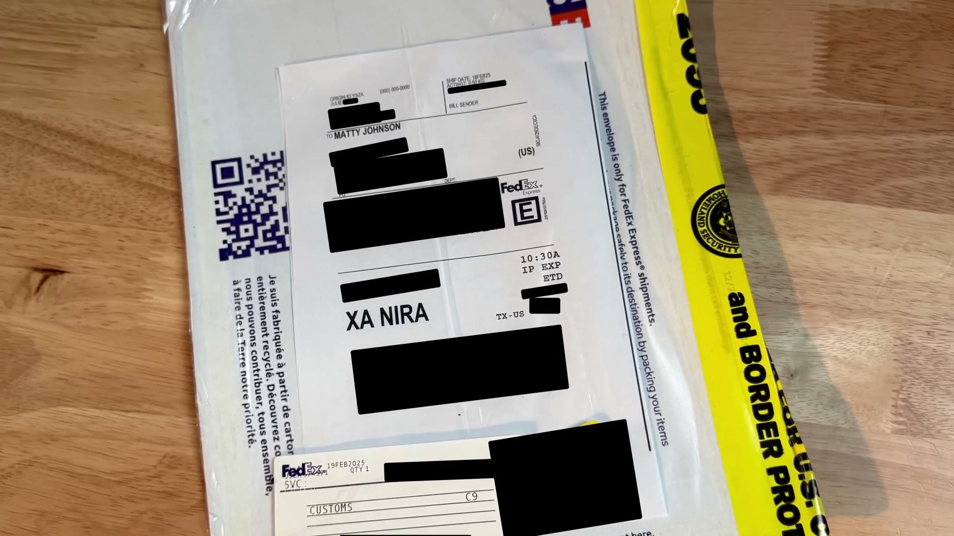 A FedEx envelope on a table with most of the shipping label redacted, showing it was addressed to Matty Johnson