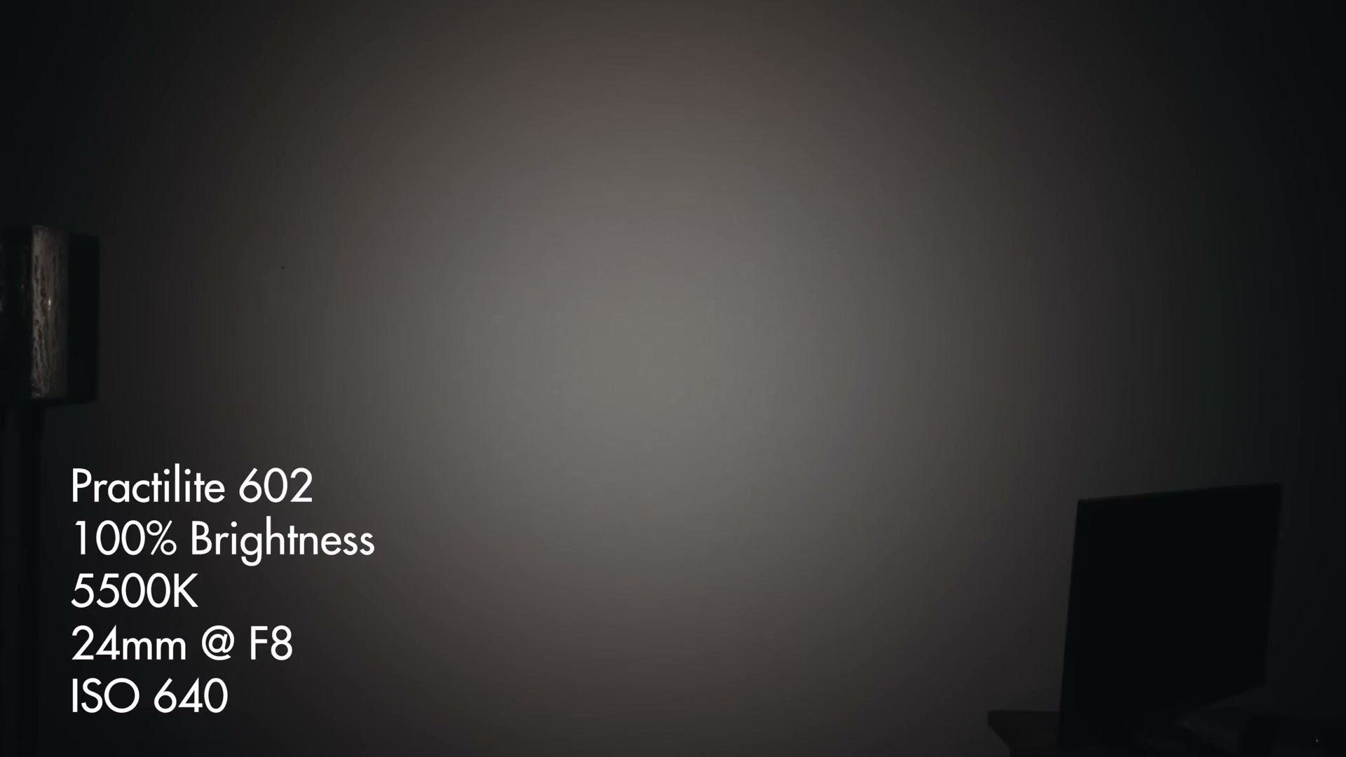 A wall lit by a spotlight with on-screen text reading Practilite 602, 100% brightness, 5500K, 24mm at F8, ISO 640.