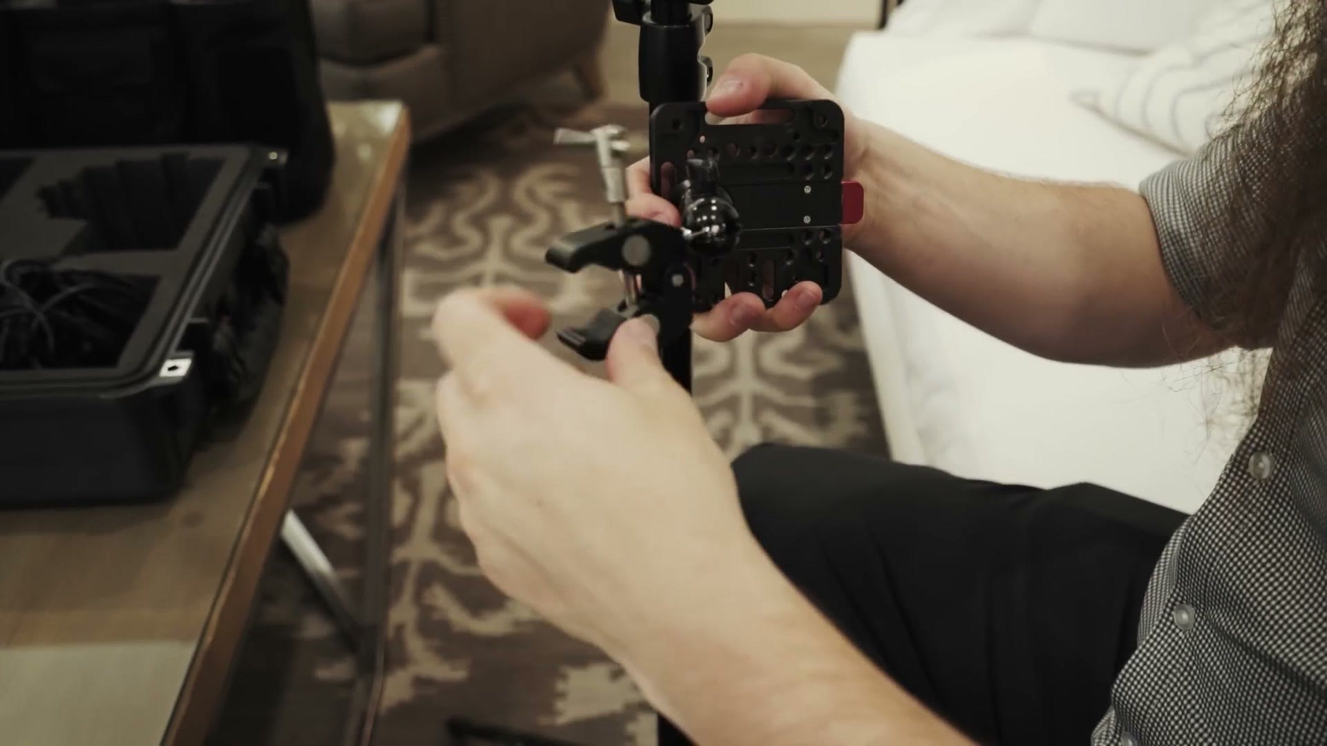 A SmallRig V-mount plate and ball head super clamp being assembled to attach a battery to a light stand.