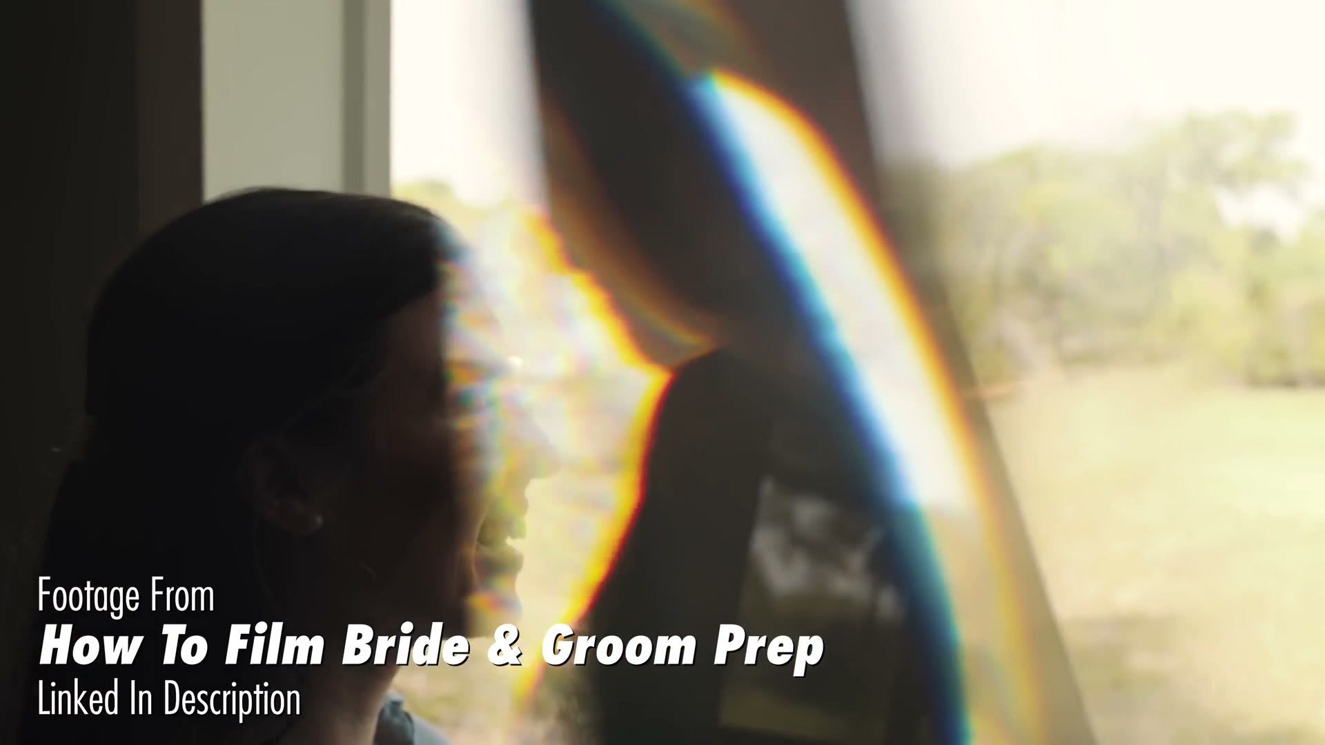A bride in profile against a bright window, with a wide rainbow refraction band running through the blown-out side of the frame