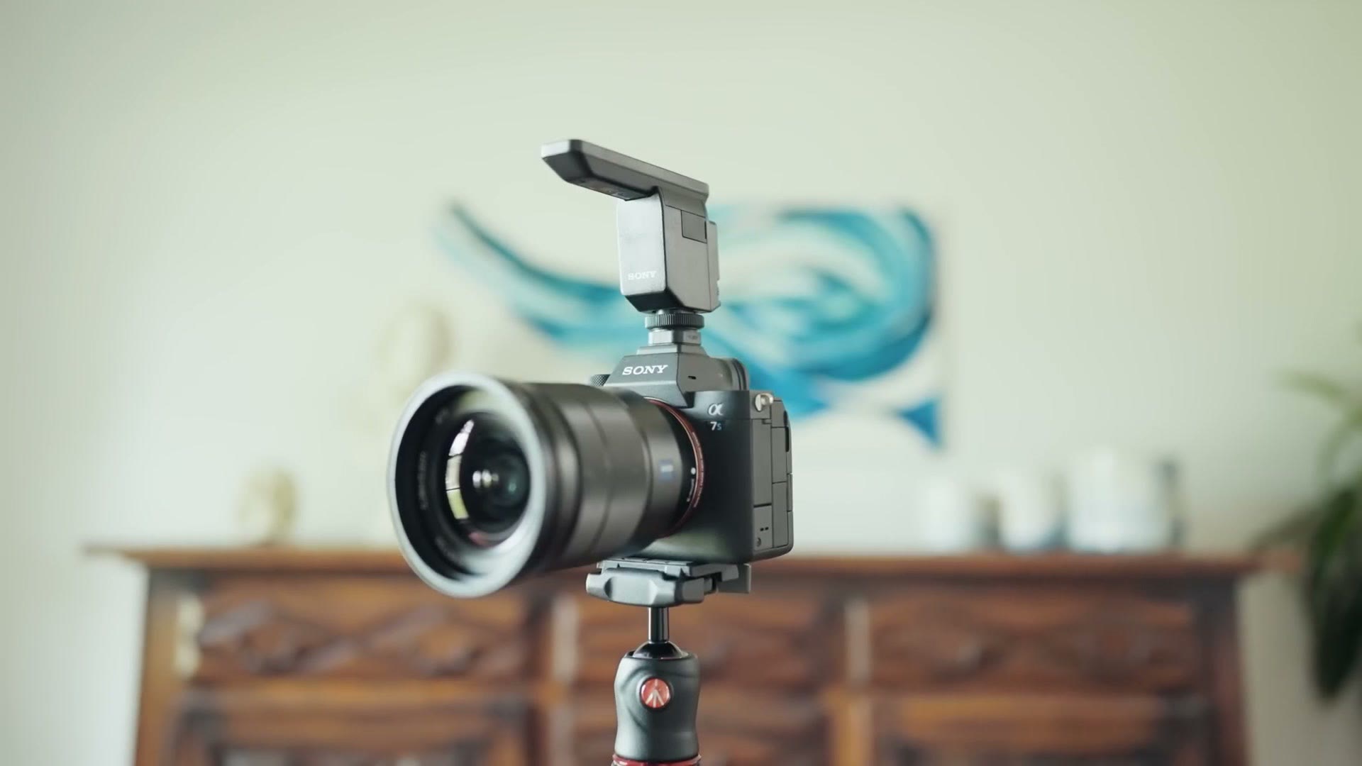 Sony camera on a tripod with a shotgun microphone mounted in the hot shoe