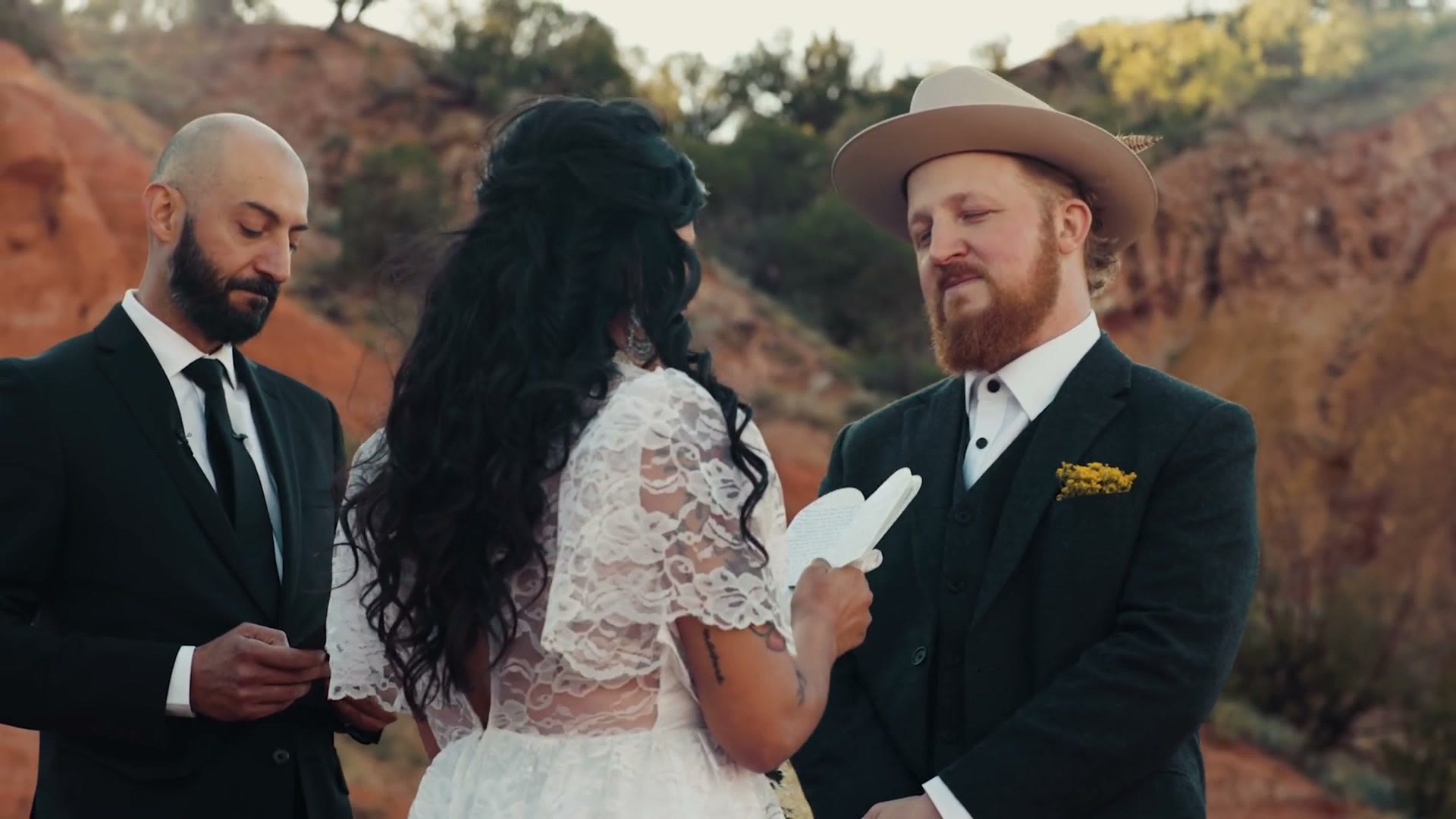 The couple reading their vows with the officiant