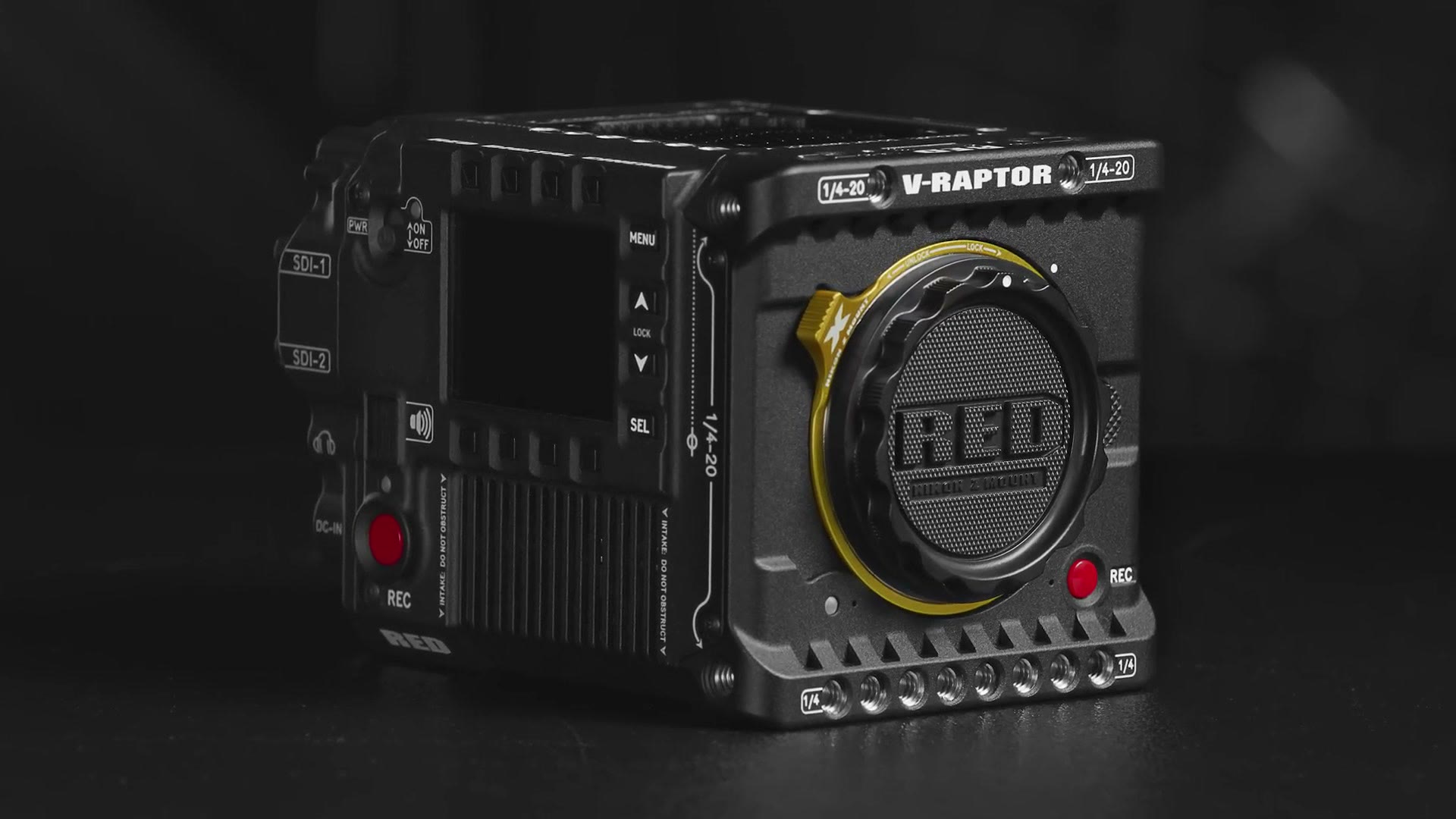 A RED V-Raptor cinema camera on a dark surface with a yellow Nikon Z mount ring around the lens opening