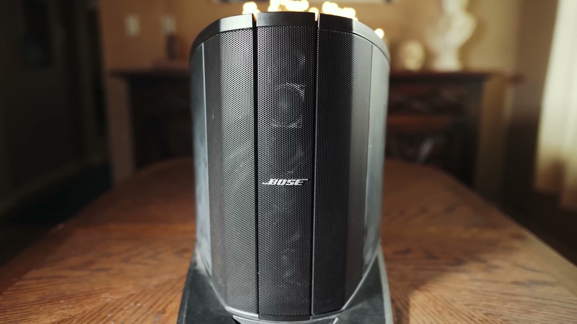 A Bose L1 line array speaker sitting on a wooden table