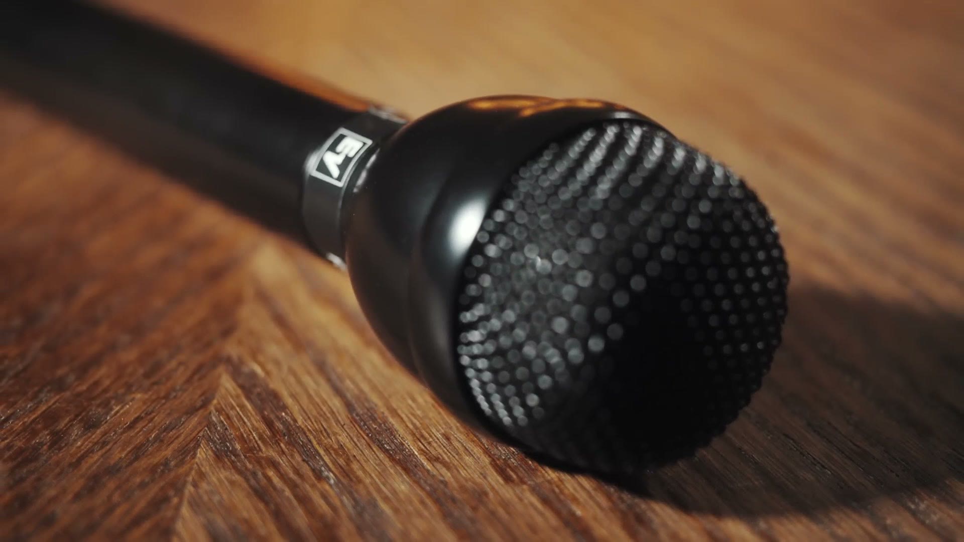 An Electro-Voice RE50N/D-B handheld microphone lying on a wooden table