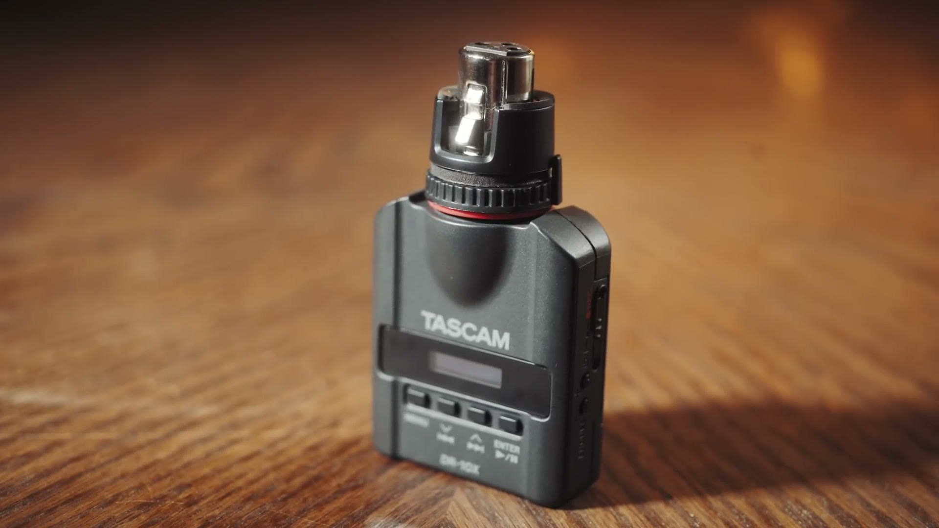 A Tascam DR-10X audio recorder standing upright with its XLR input on top