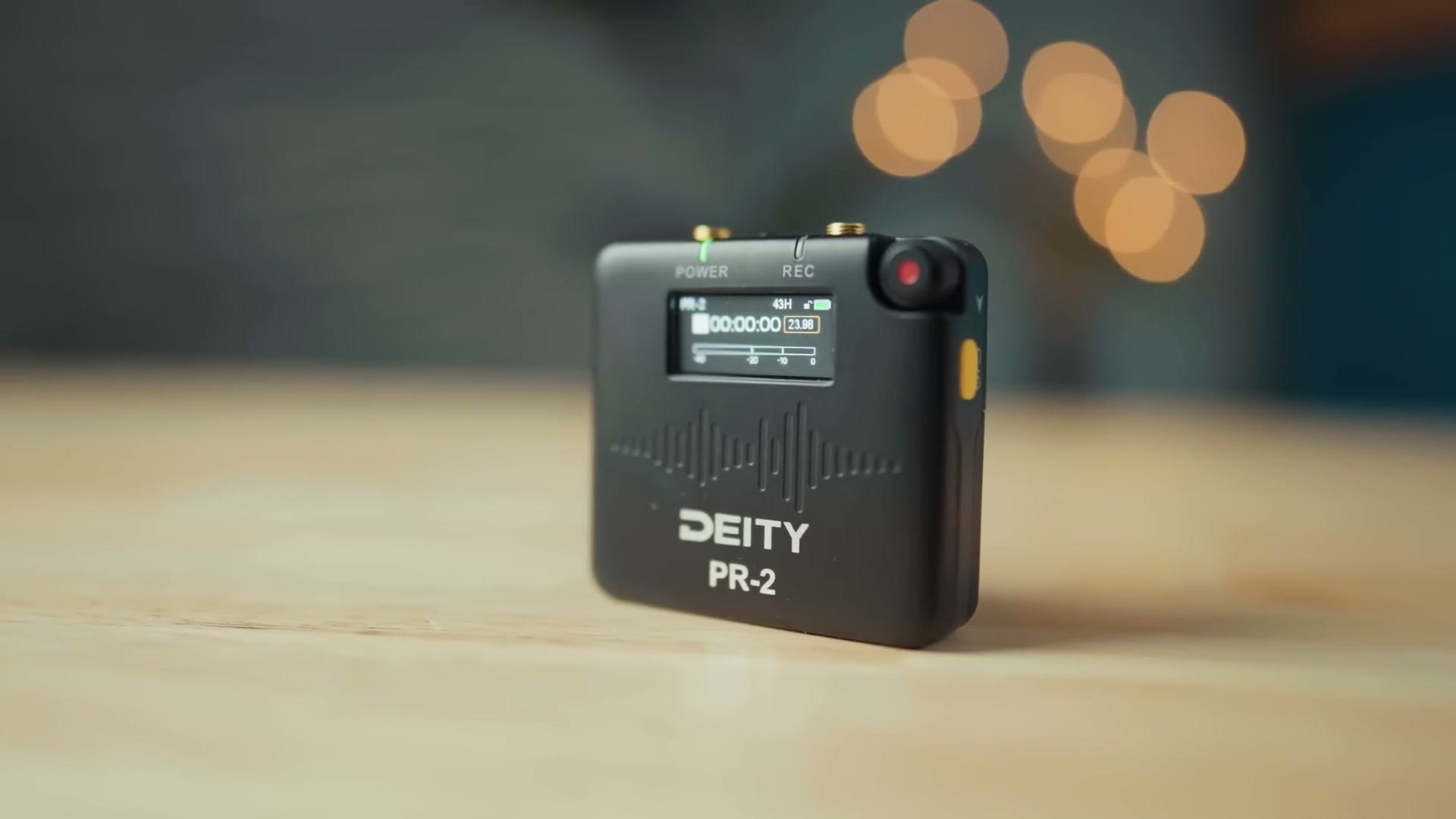 Deity PR-2 audio recorder standing on a desk with its screen lit