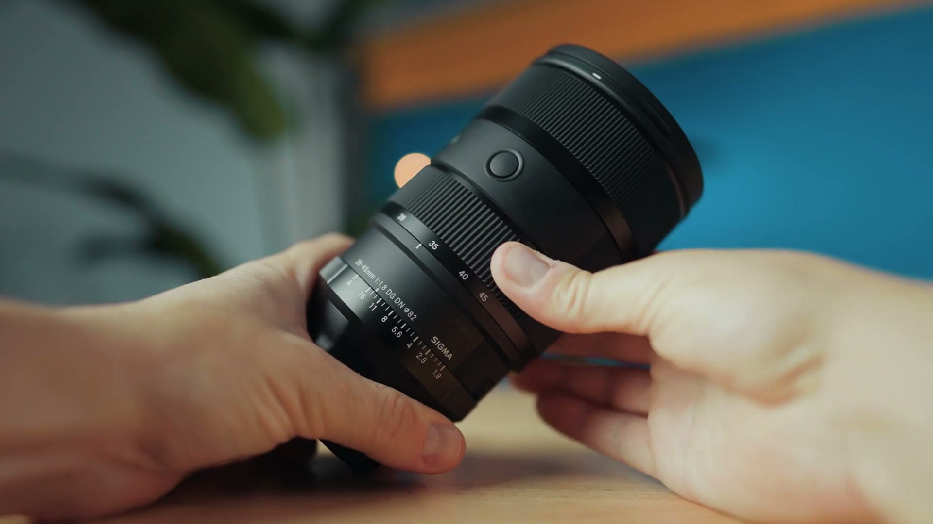 The Sigma 28-45 lens held in one hand