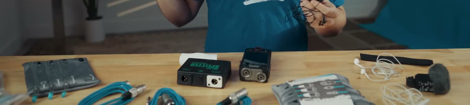 An XLR splitter and a multitrack audio recorder sitting on a desk with cables