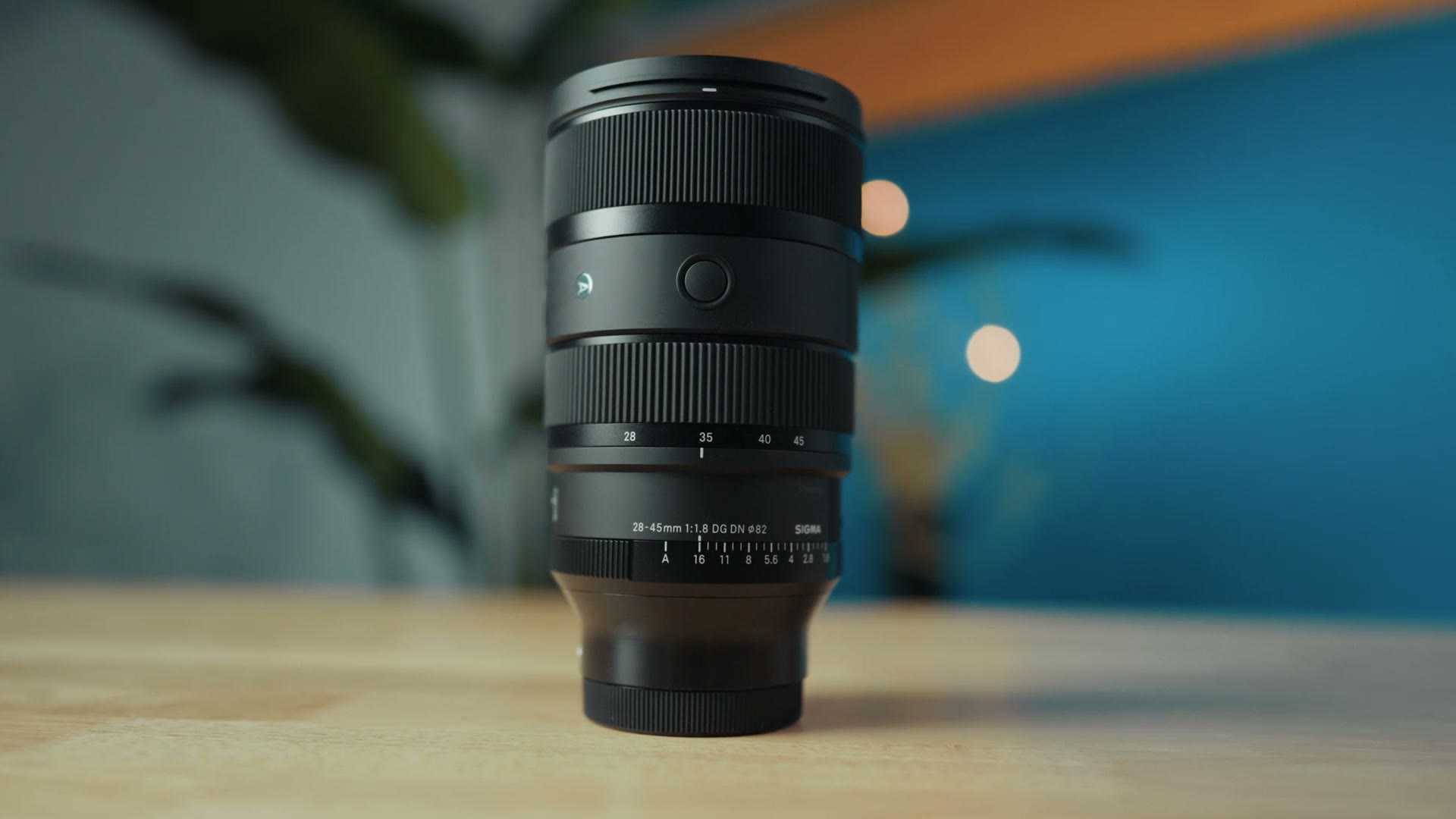 Sigma 28-45 f1.8 lens on a desk with the studio background behind it