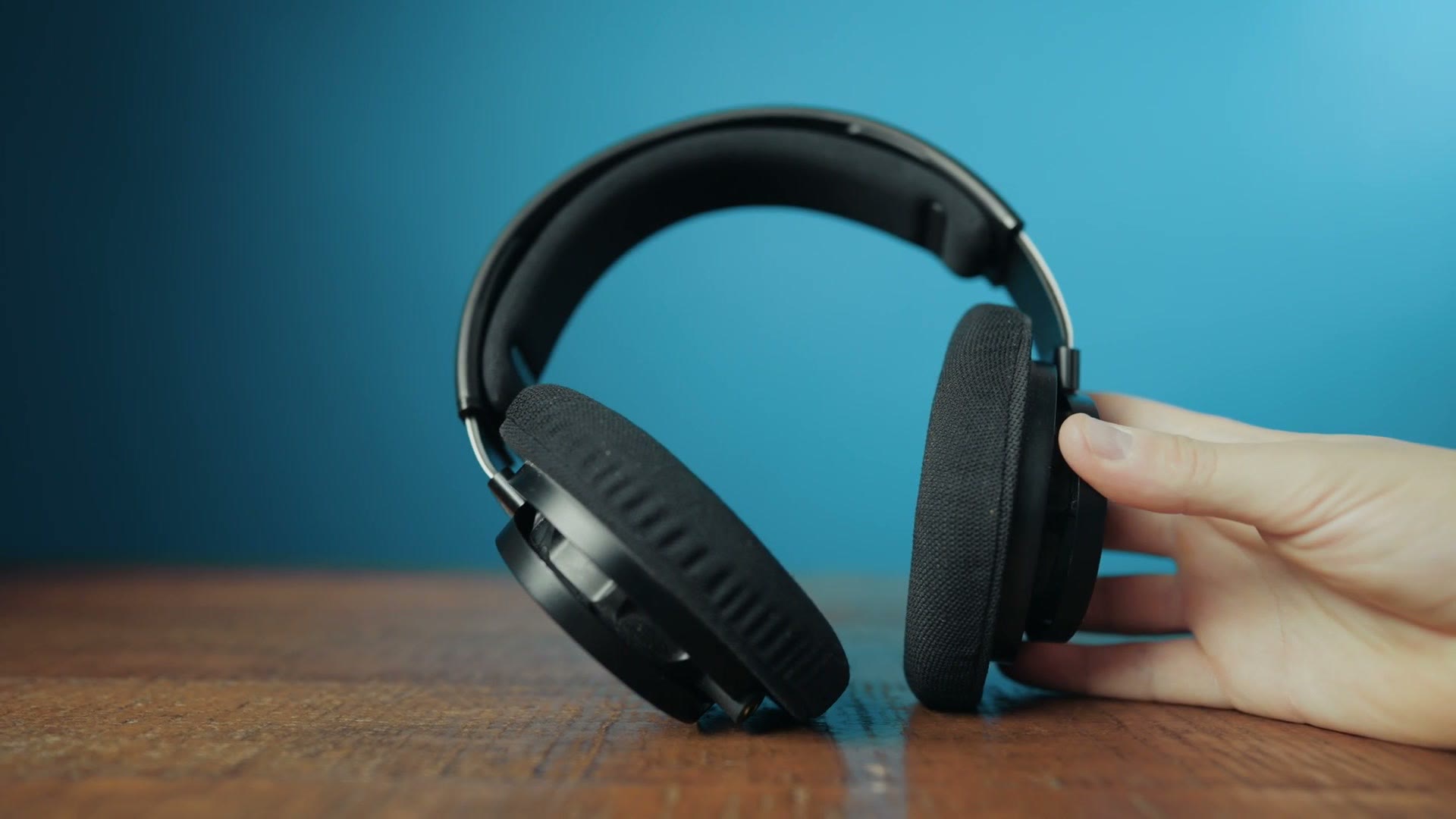 The Philips SHP9500 headphones held up in one hand to show their size
