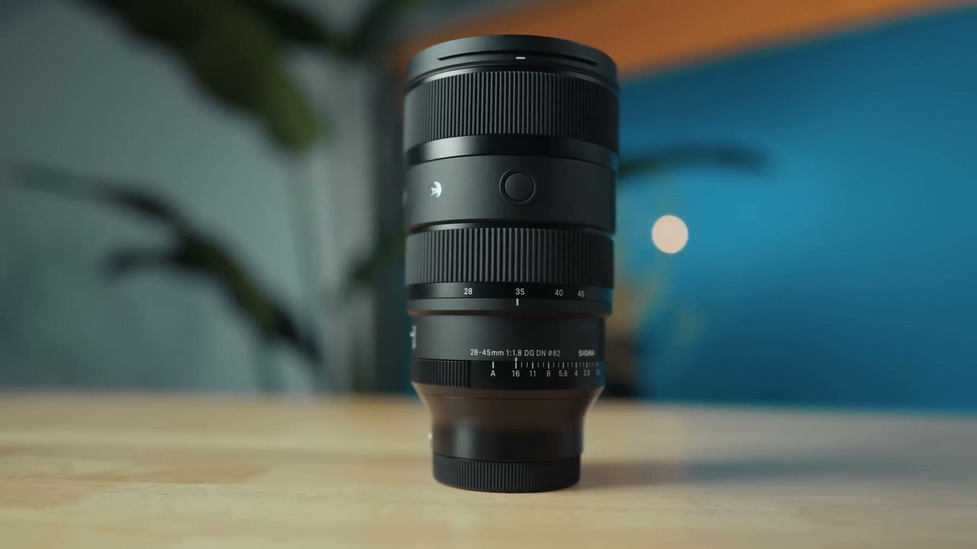 The Sigma 28-45mm f/1.8 DG DN Art lens on a wooden table