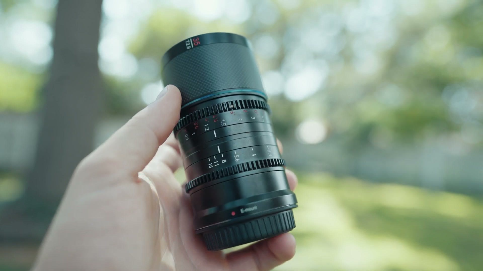 Matt Johnson holding the Sirui Saturn 35mm anamorphic lens outdoors