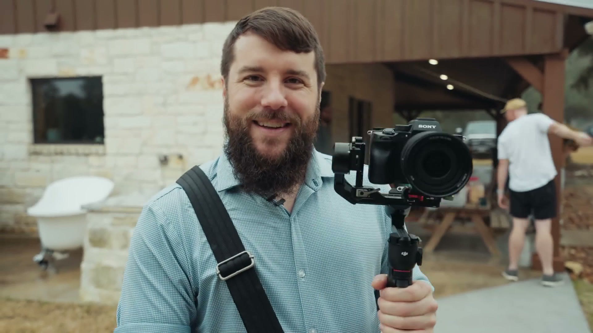 Matt holding a Sony camera on a small gimbal outside a ranch venue