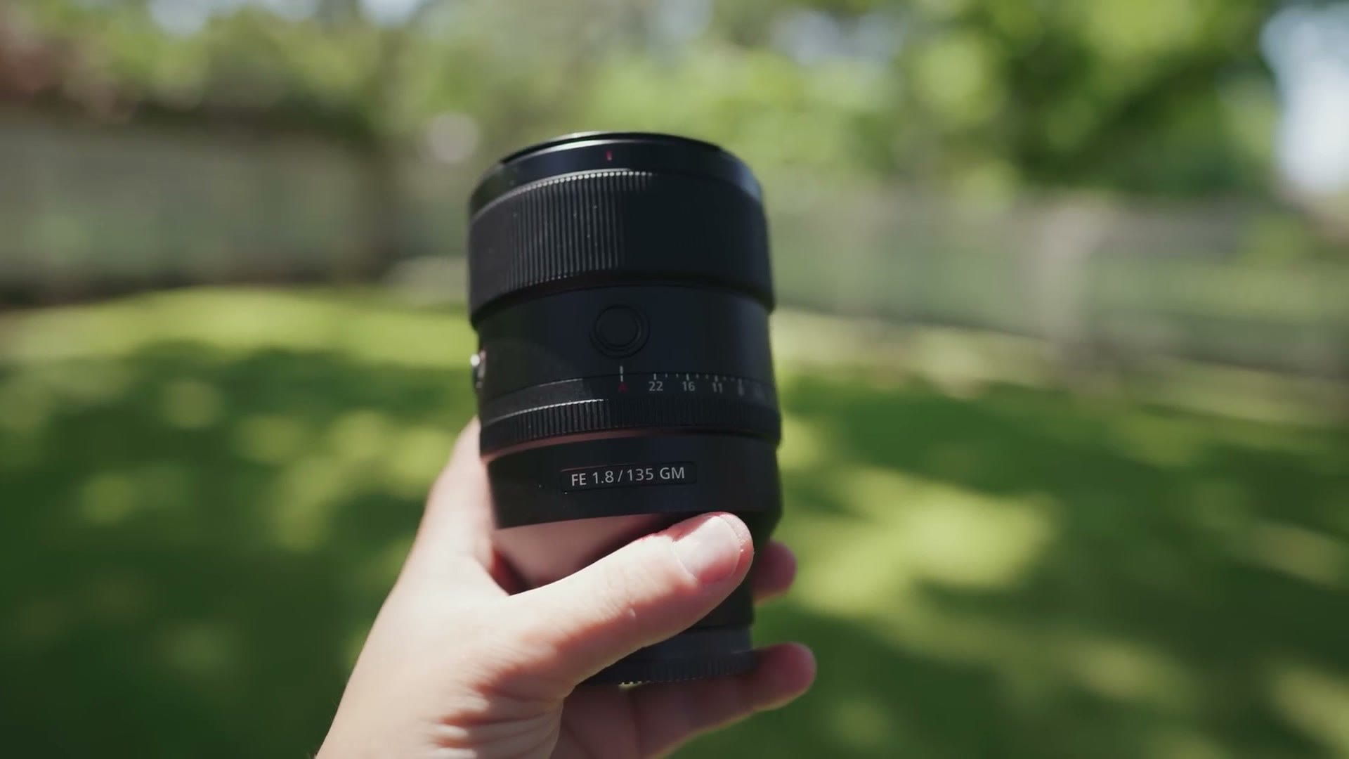 The Sony 135mm f/1.8 GM lens held up outdoors