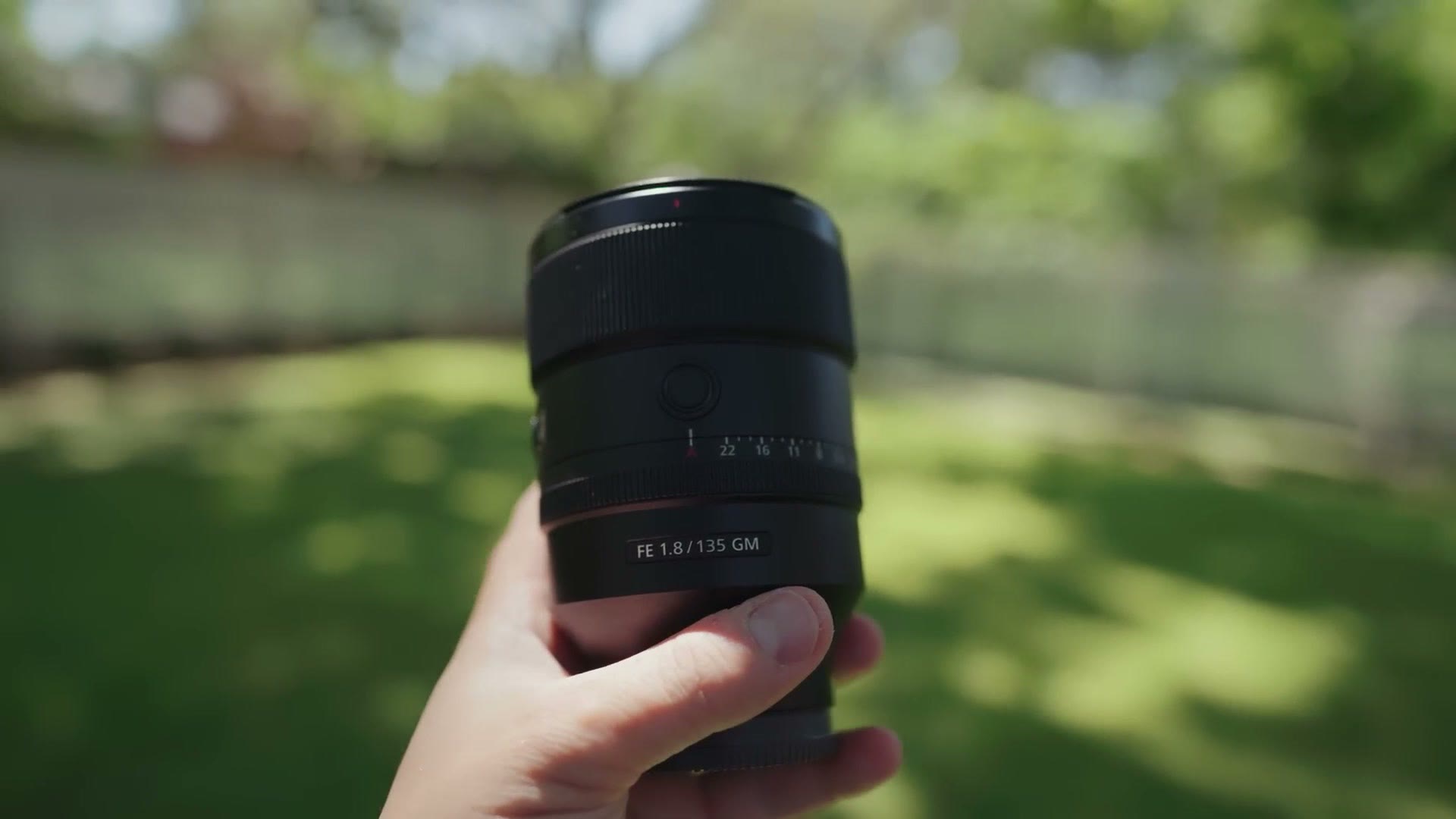 The Sony 135mm GM held in one hand showing how compact it is