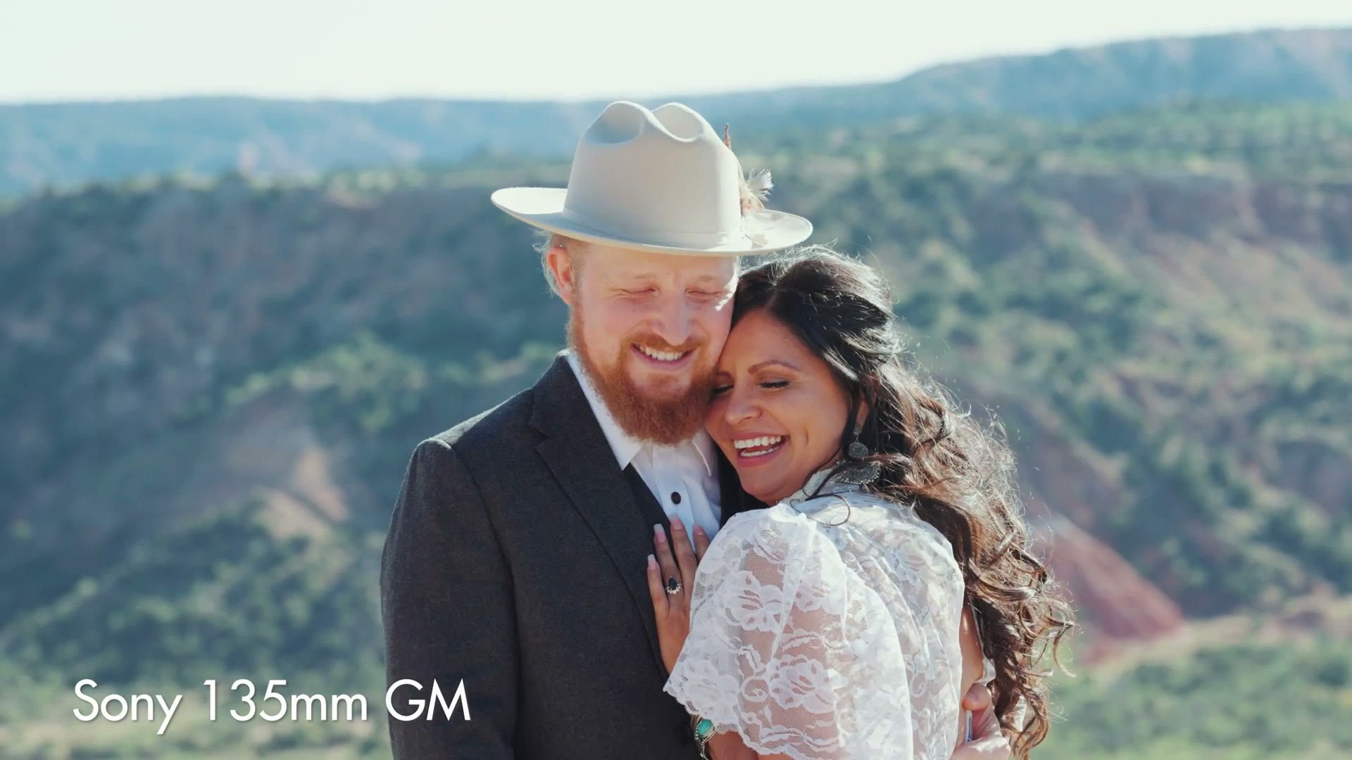 A couple embracing in a field, filmed on the Sony 135mm GM