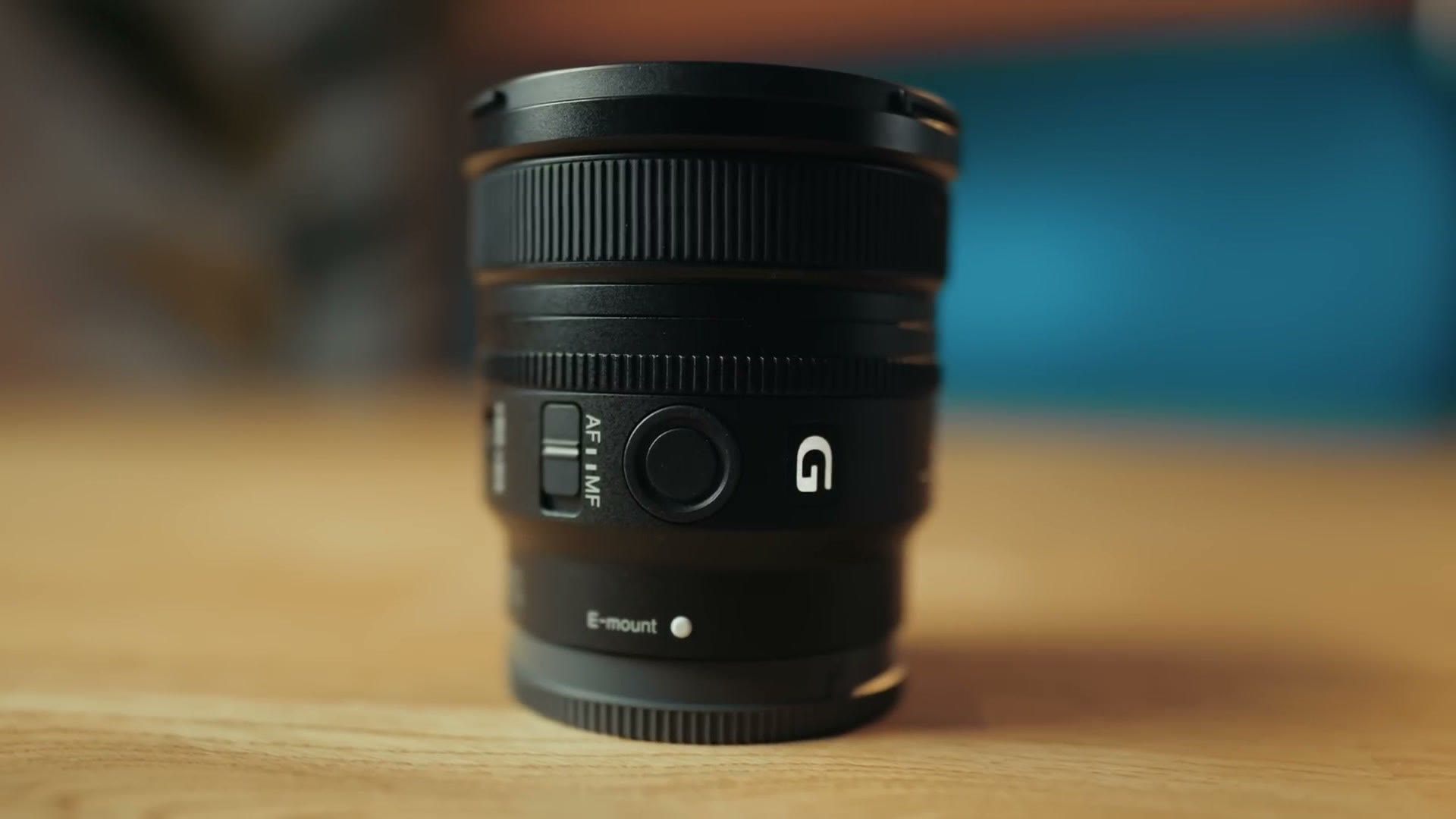 Close up of the side of the Sony FE 16mm f/1.8 G lens showing the AF and MF switch, the programmable focus hold button, the G badge and the E-mount marking