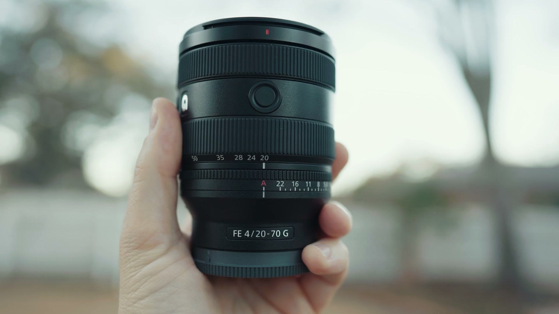 The Sony 20-70mm F4 G held up in one hand outdoors