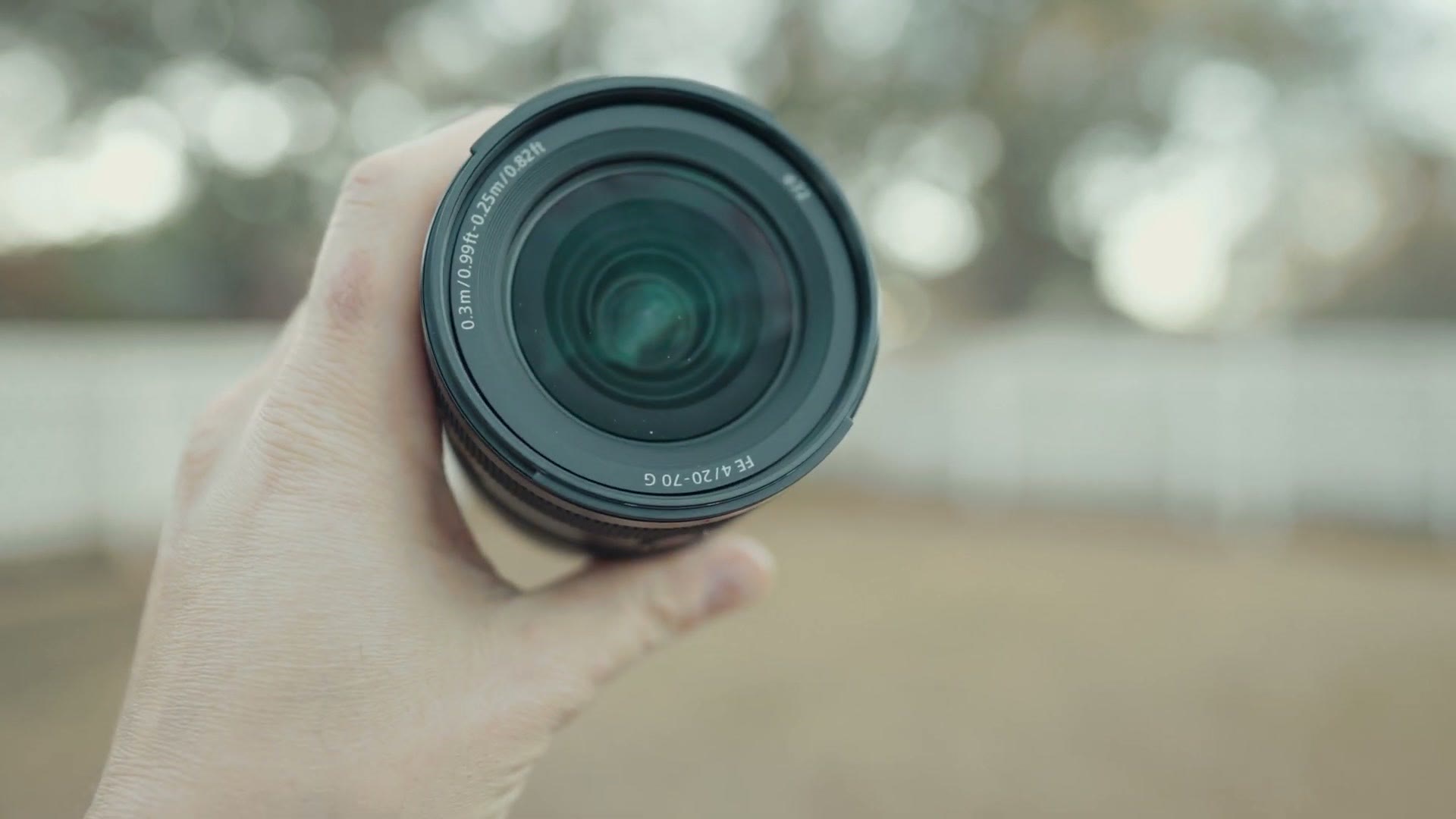The front element of the Sony 20-70mm F4 G held in one hand