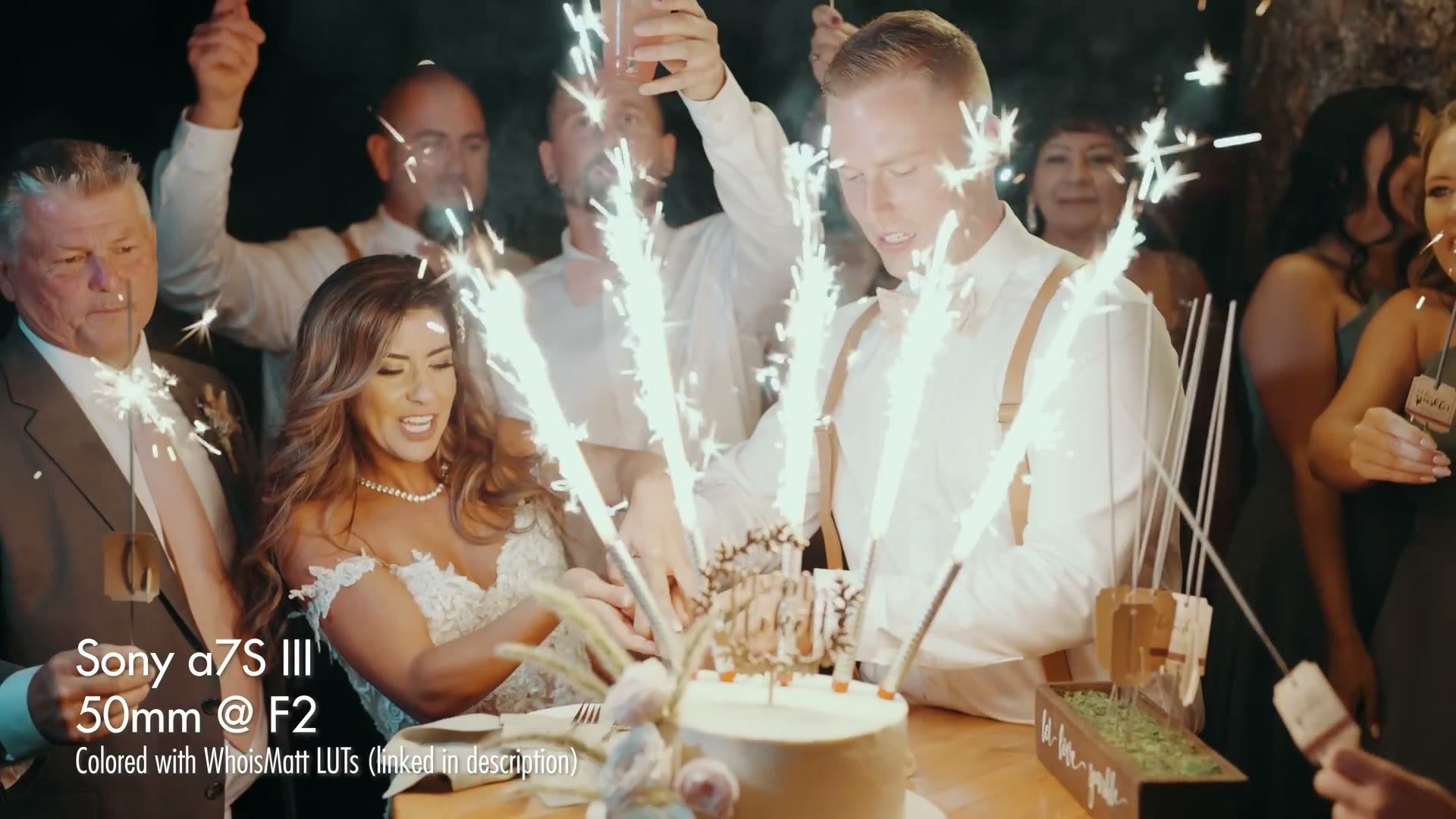 A couple cutting their cake surrounded by sparkler candles, filmed at 50mm f/2