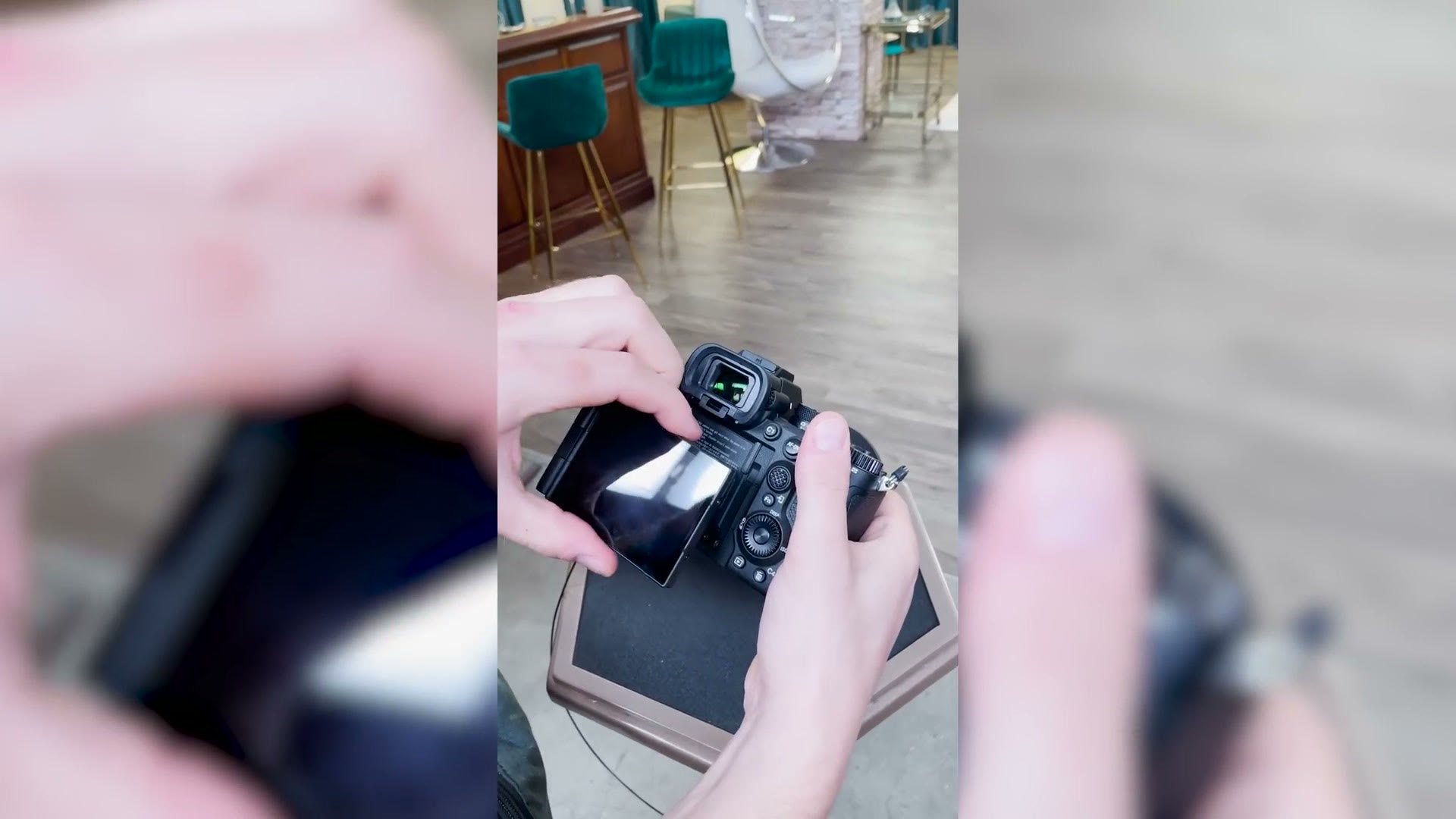 Hands tilting and flipping out the a7R V rear screen