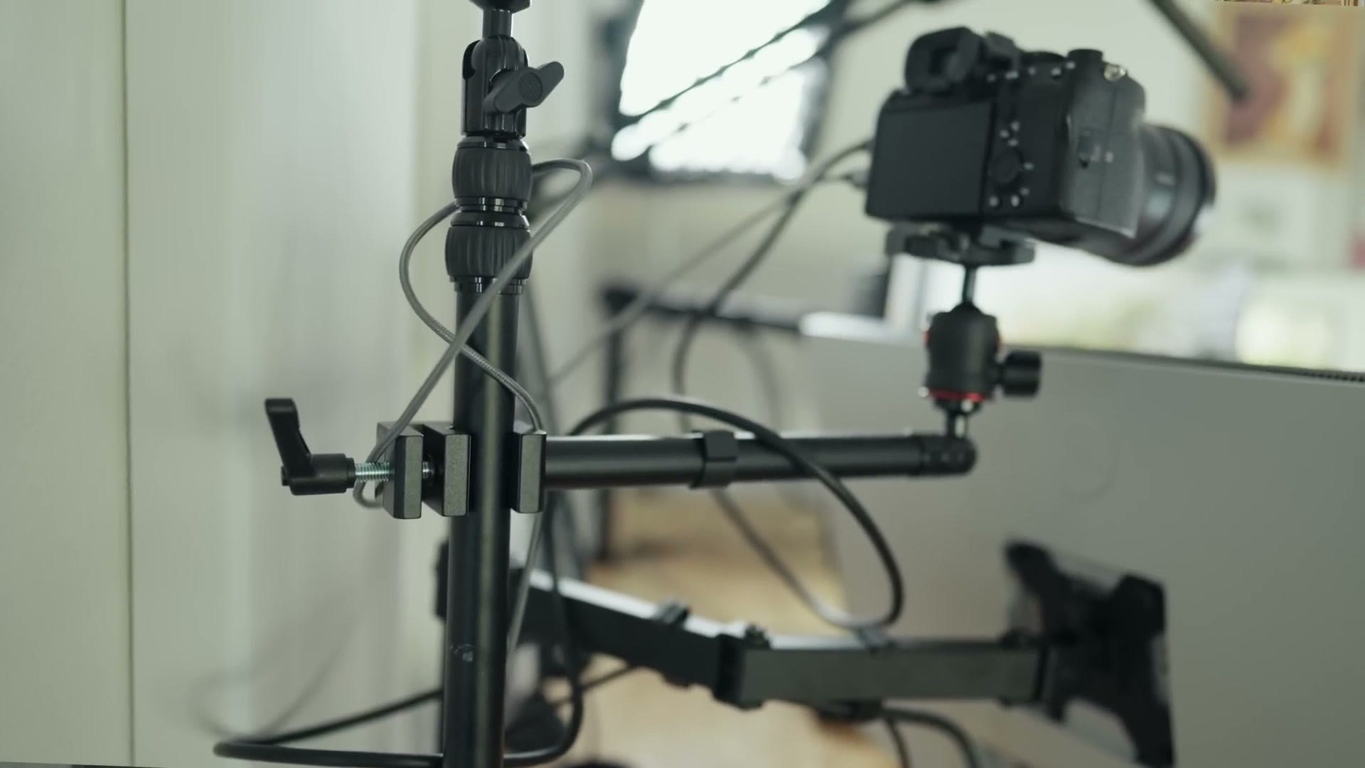 Camera mounted on a desk arm above the monitor