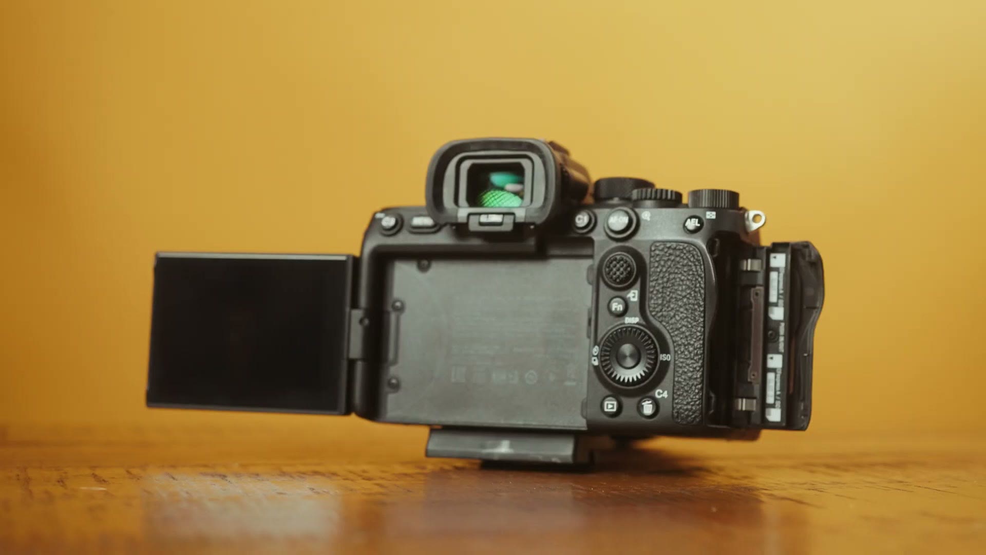 A Sony camera on a table with its rear screen flipped out from the body