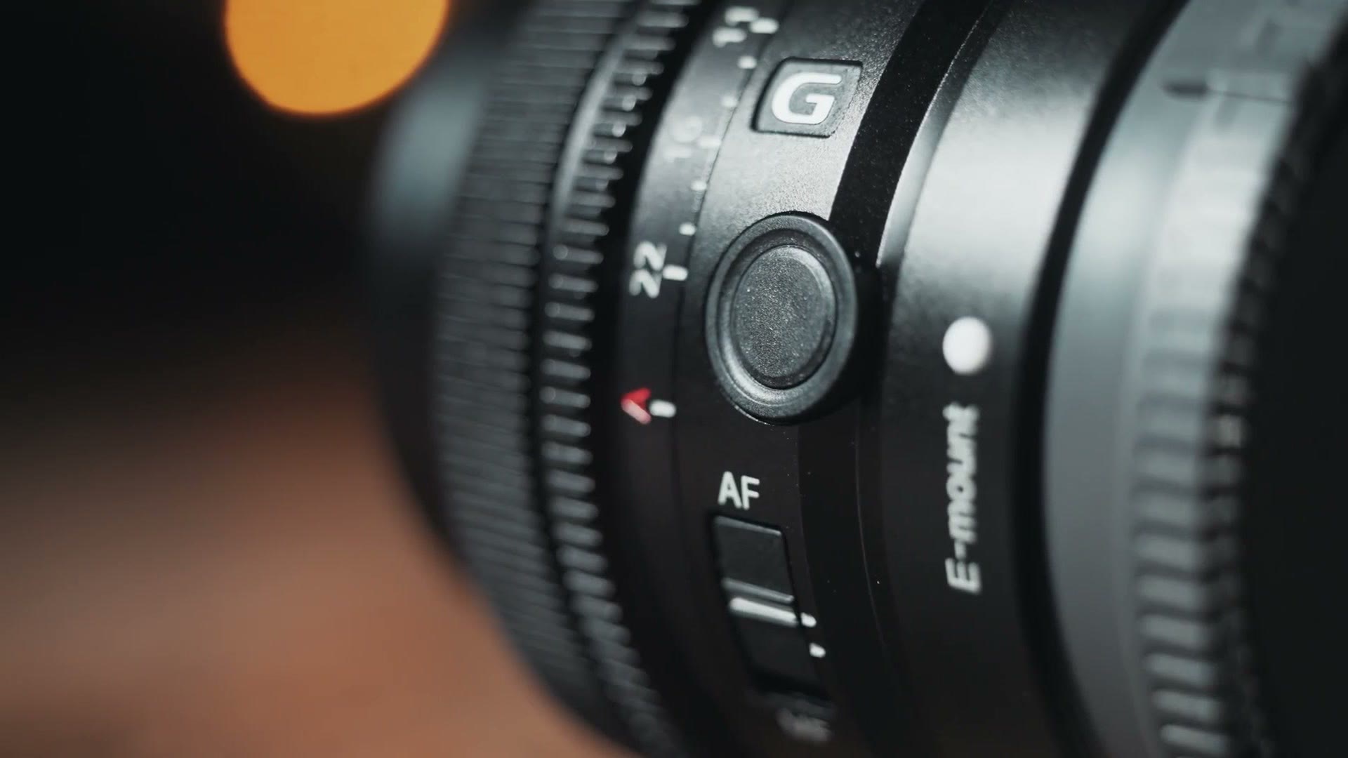 The G badge, customizable button and AF/MF switch on the barrel of a Sony compact prime