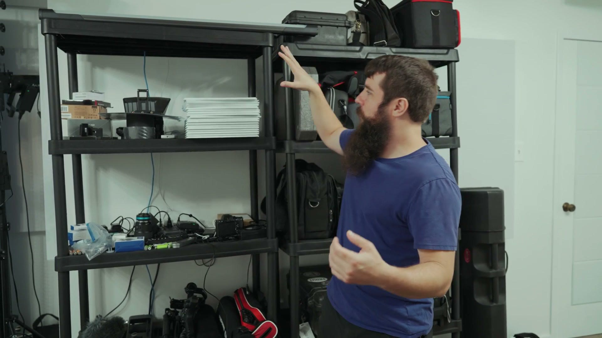 Shelving unit holding camera bags, cases and accessories