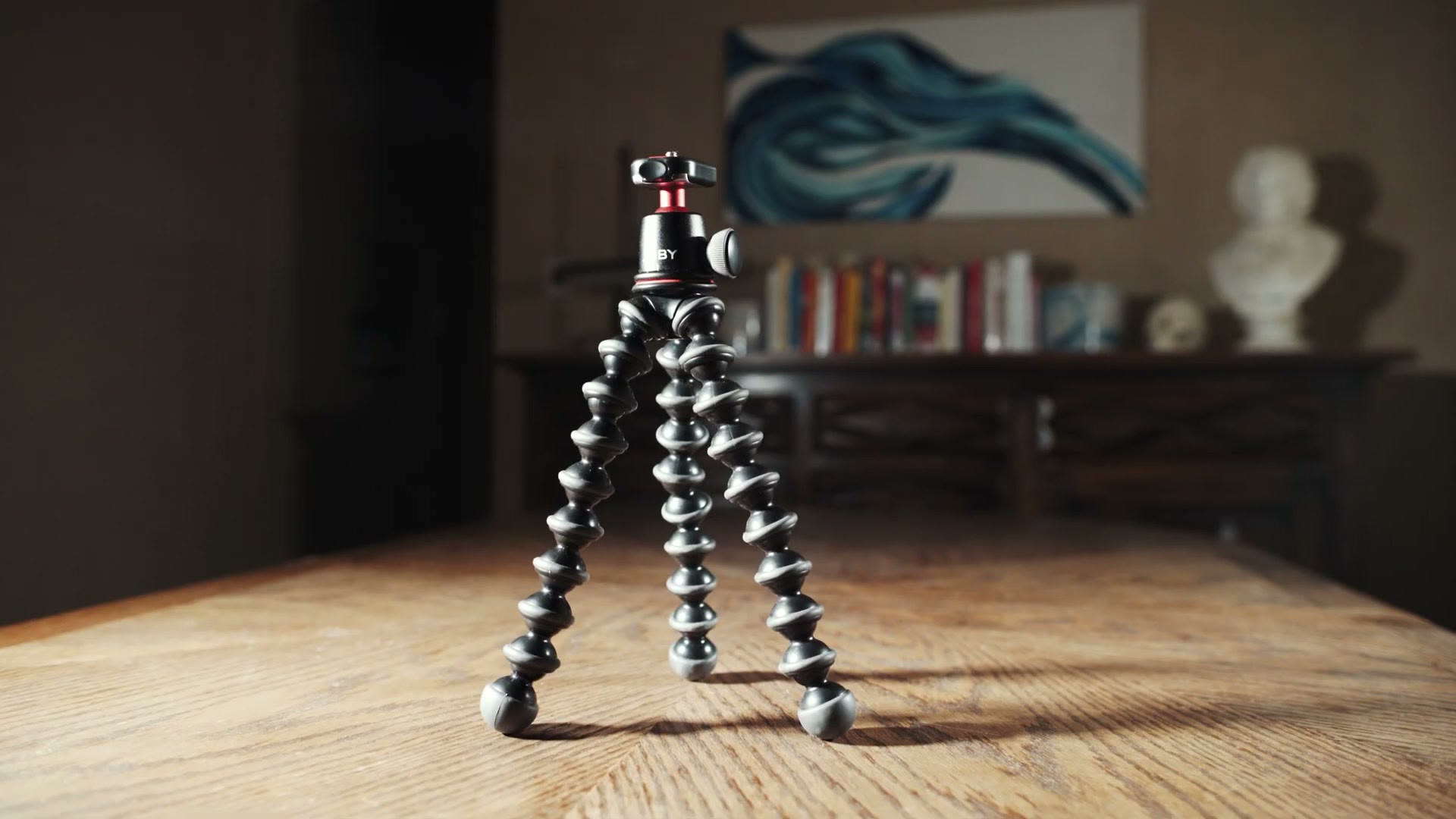 A Joby Gorillapod with its three ball jointed legs splayed out, standing on a wooden table