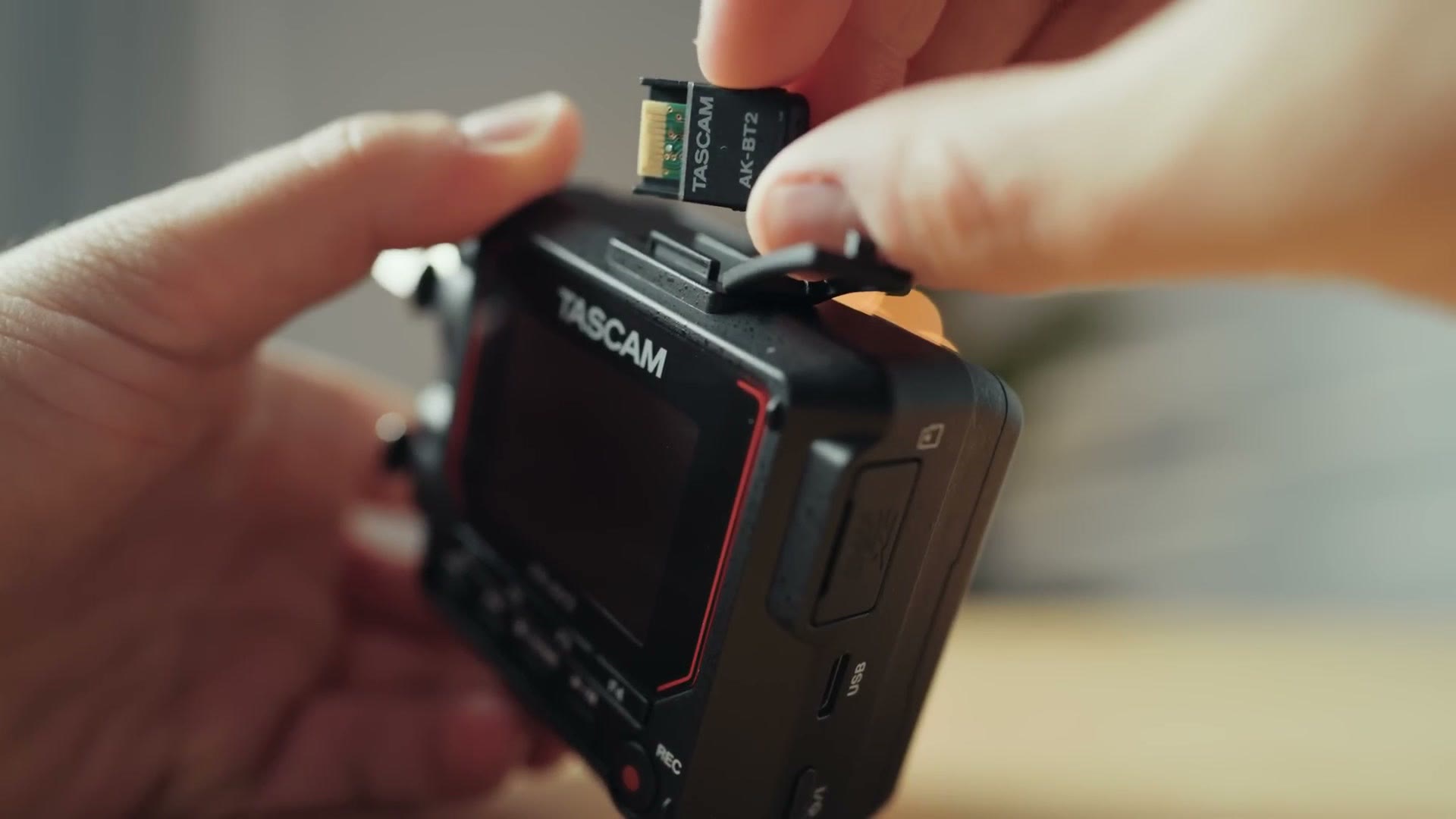 The Tascam AK-BT2 Bluetooth adapter being slid into the FR-AV2