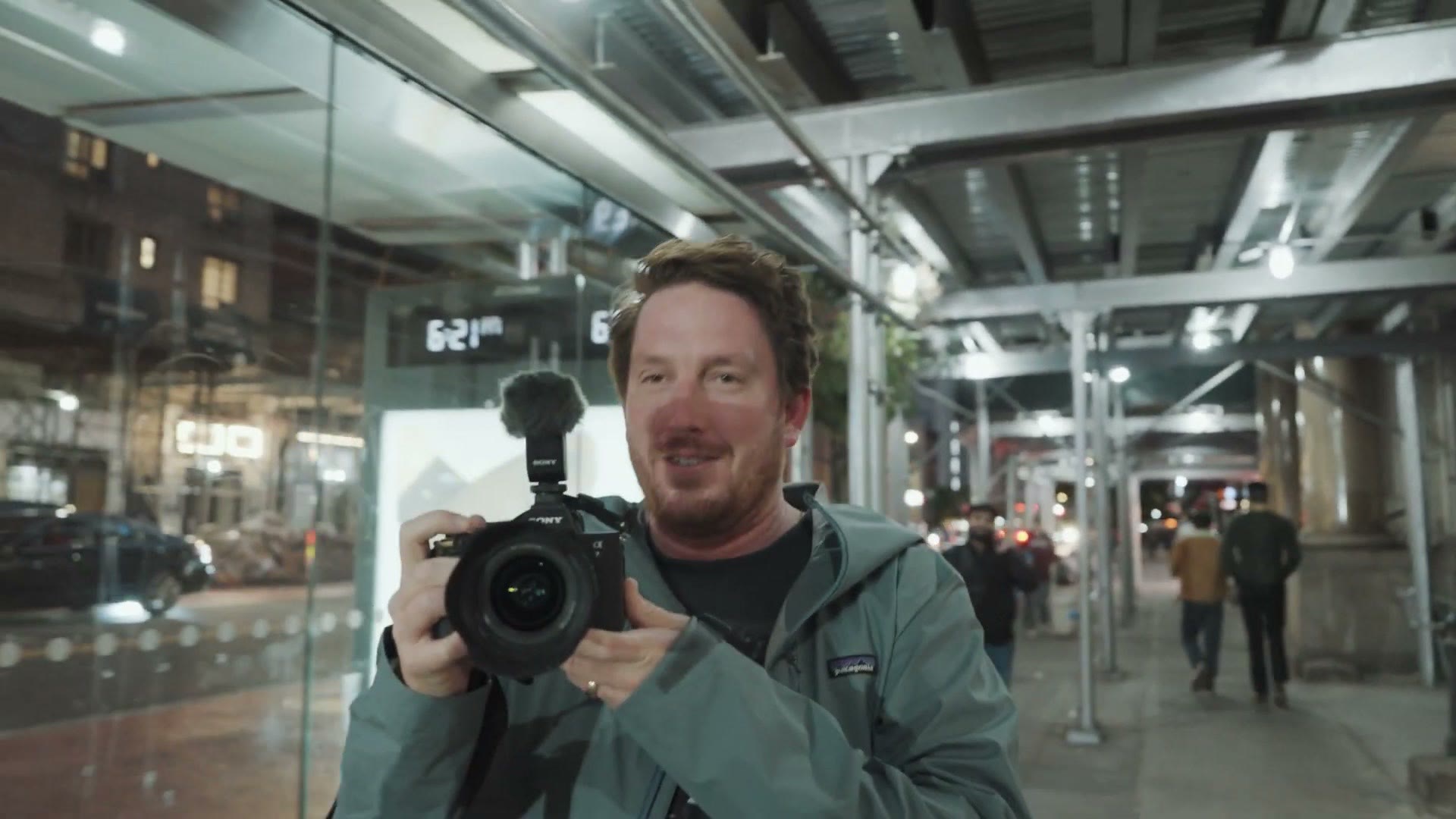 Taylor Jackson holding a camera on a New York City street under an overpass