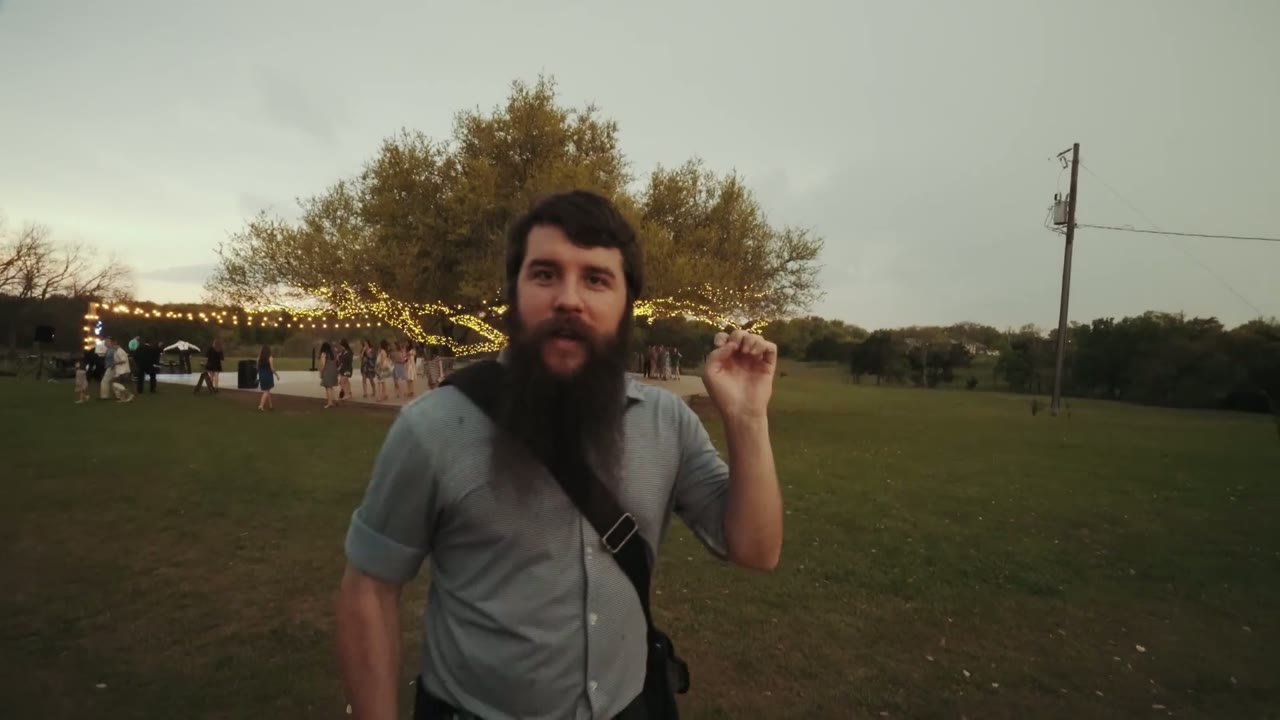 Matt talking to camera at dusk with string lights strung through a tree and a thunderstorm rolling in behind him