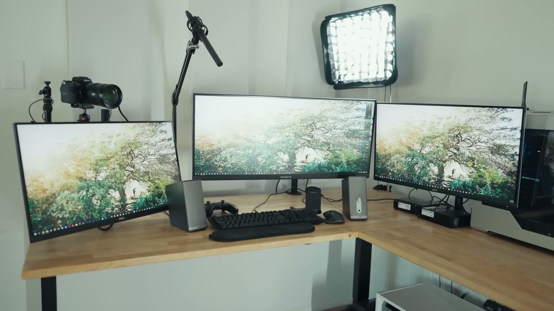 Three monitors mounted above the desk