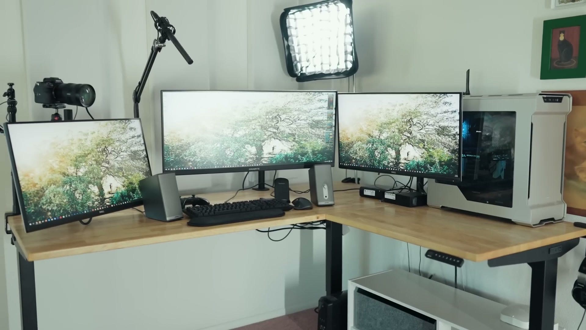 Wide view of a triple monitor standing desk video editing setup