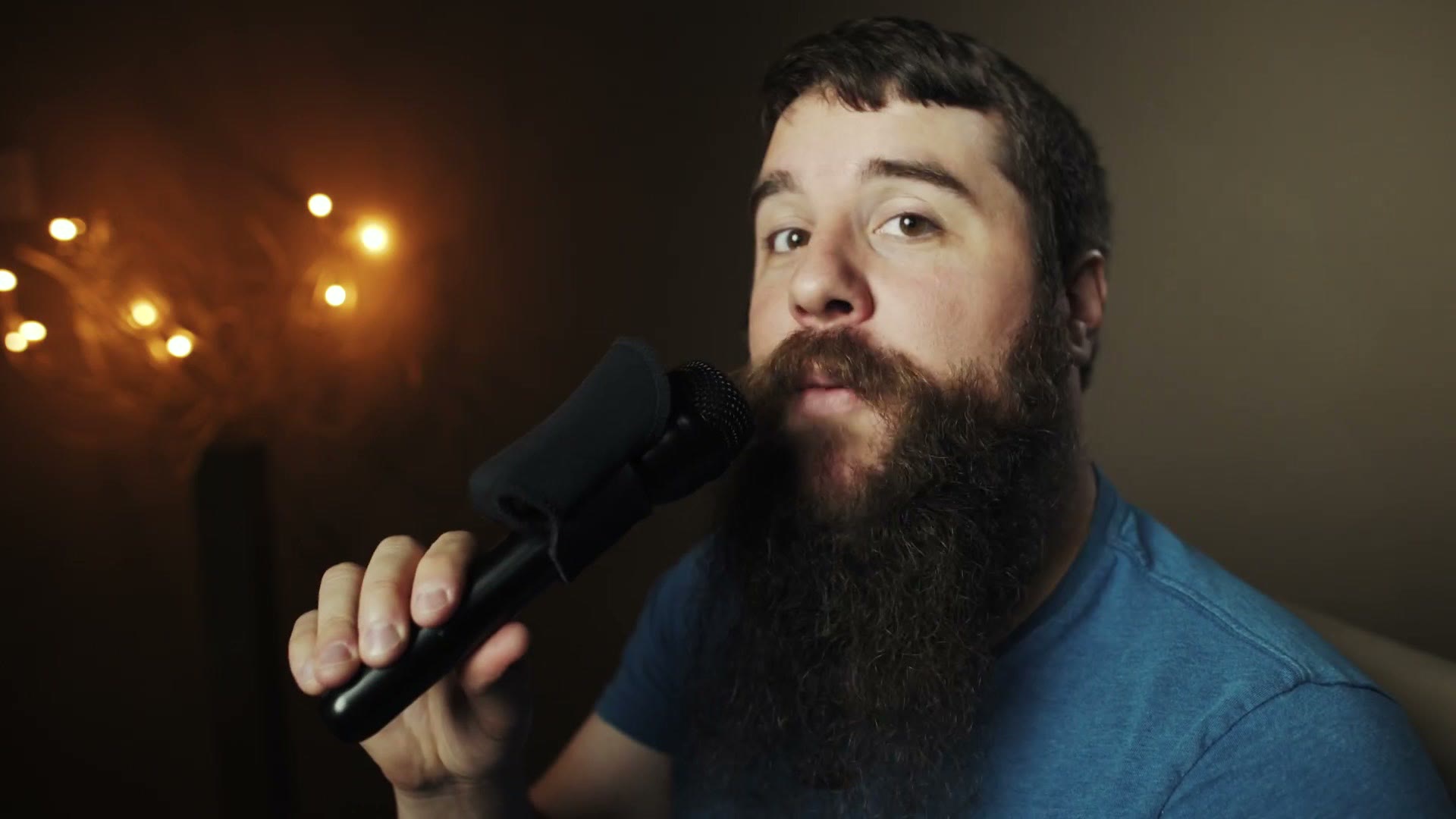 Matt holding the finished rig, a handheld microphone with the Piggy Backup and a Rode Wireless GO mounted on it, up in front of his face.