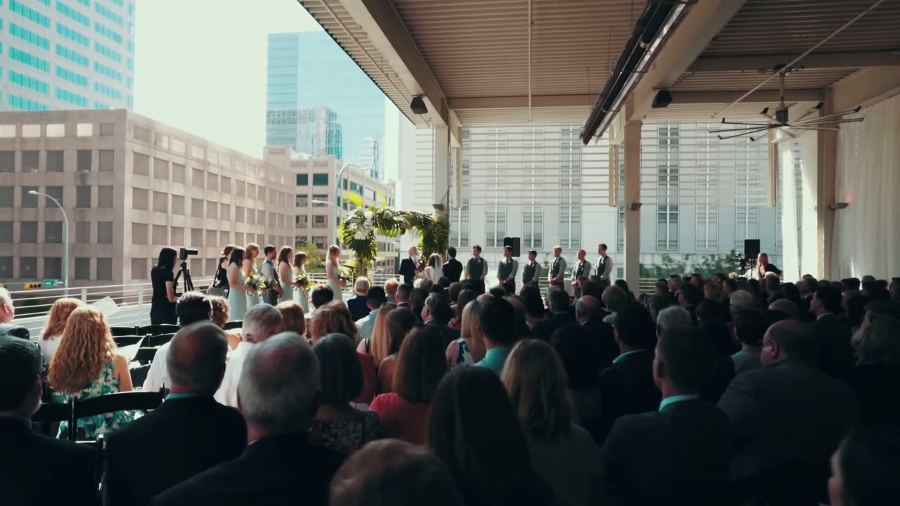 Wide view of the ceremony under a covered rooftop space with the Austin skyline behind