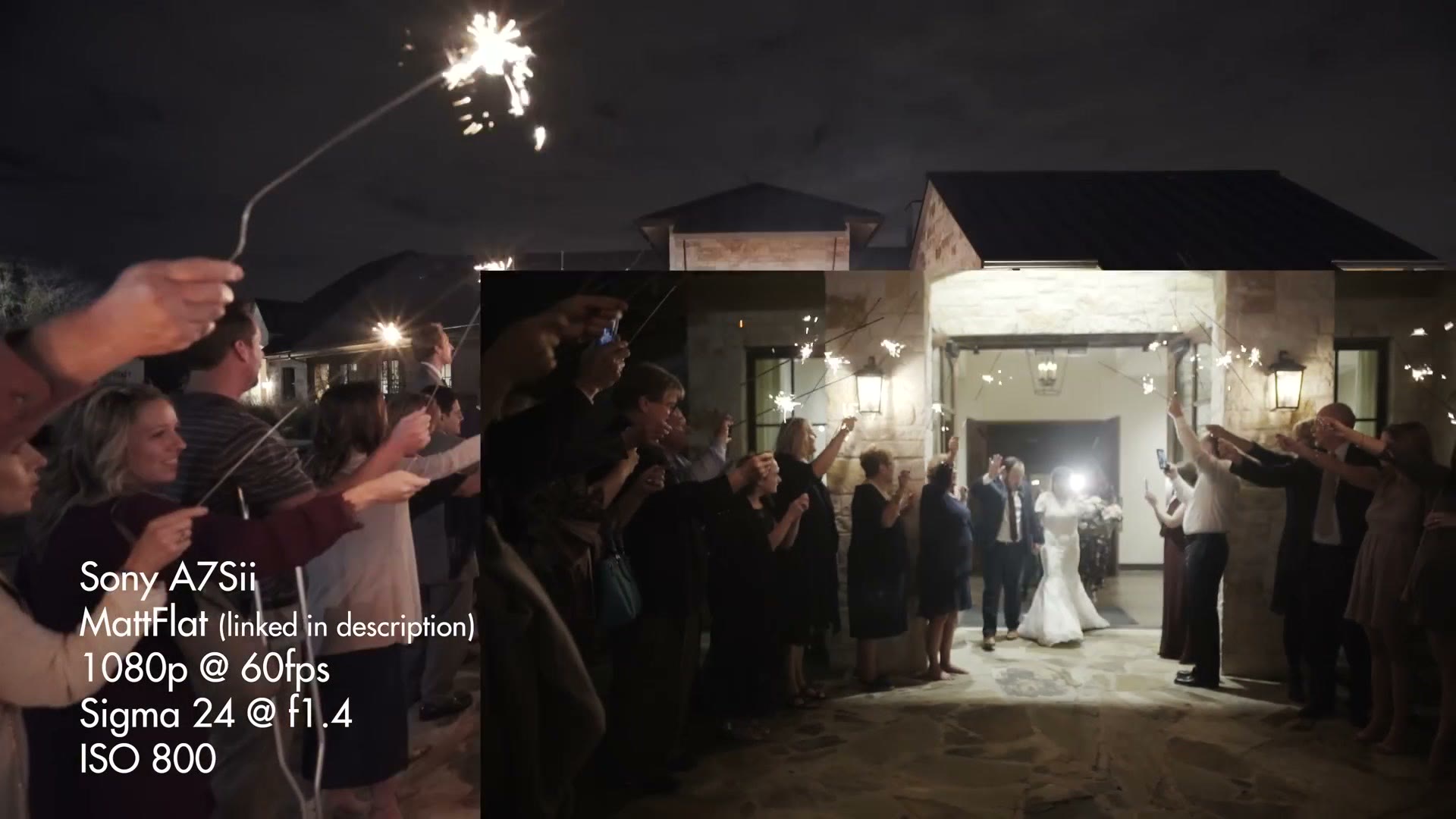 The couple walking out of the lit doorway into a corridor of guests holding sparklers, the venue glowing behind them